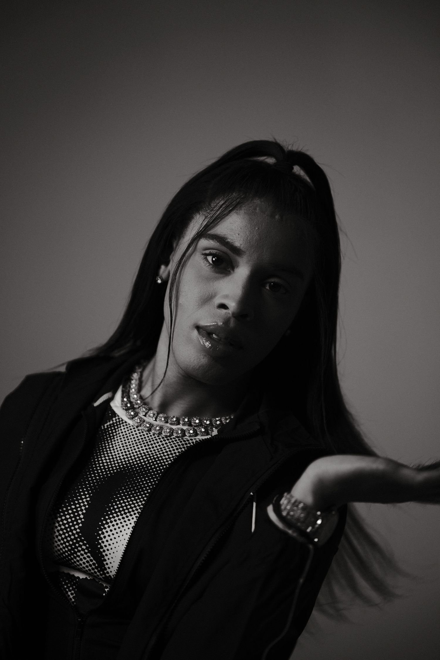 Dramatic black and white portrait series with moody lighting and jewelry details.