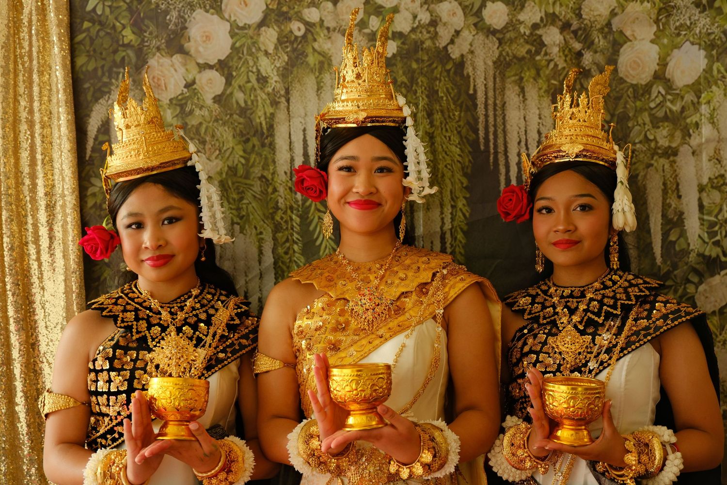 Traditional Cambodian dancers in golden costumes and headdresses performing in a line.