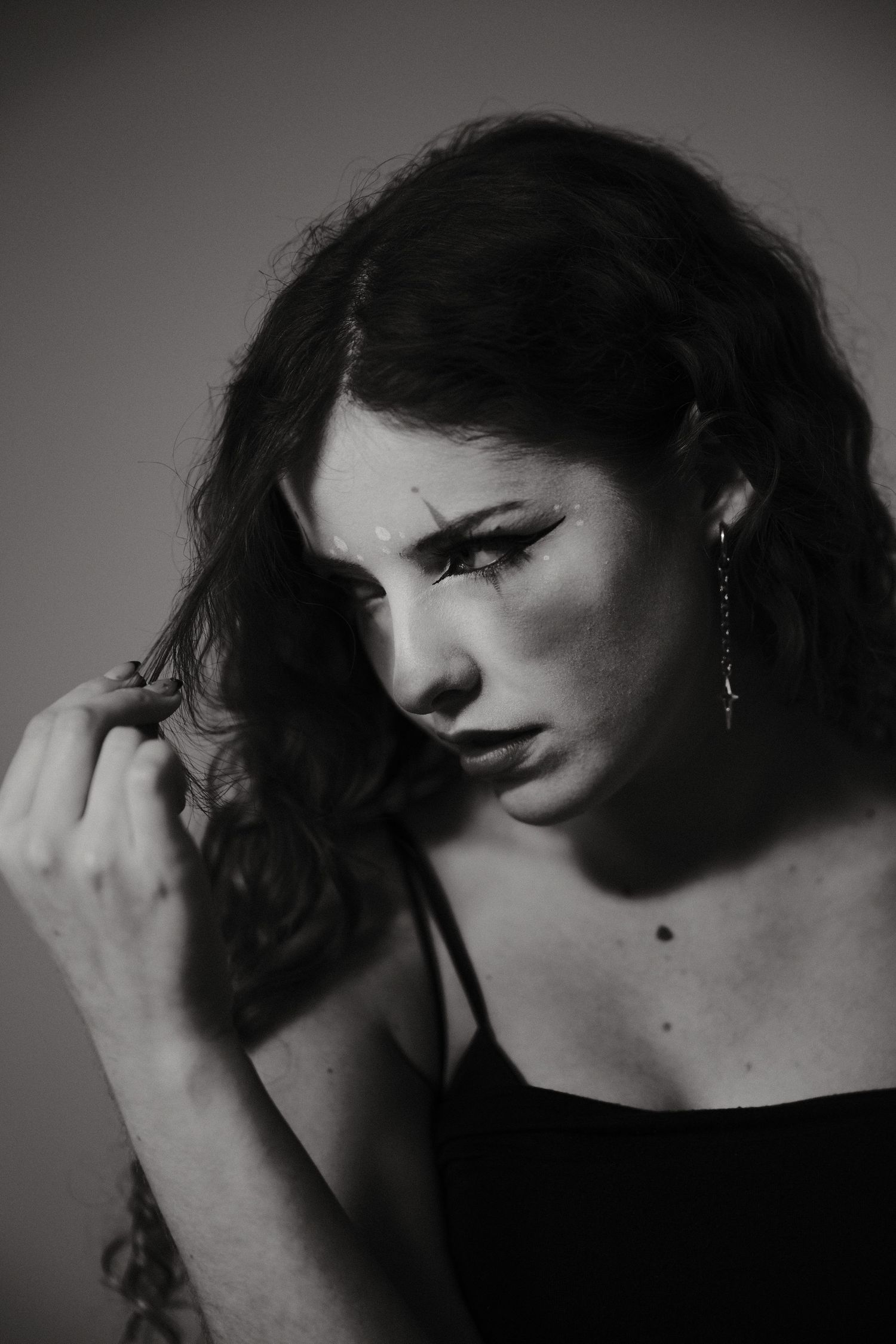 Black and white close-up portrait series with dramatic shadows and expressive poses.