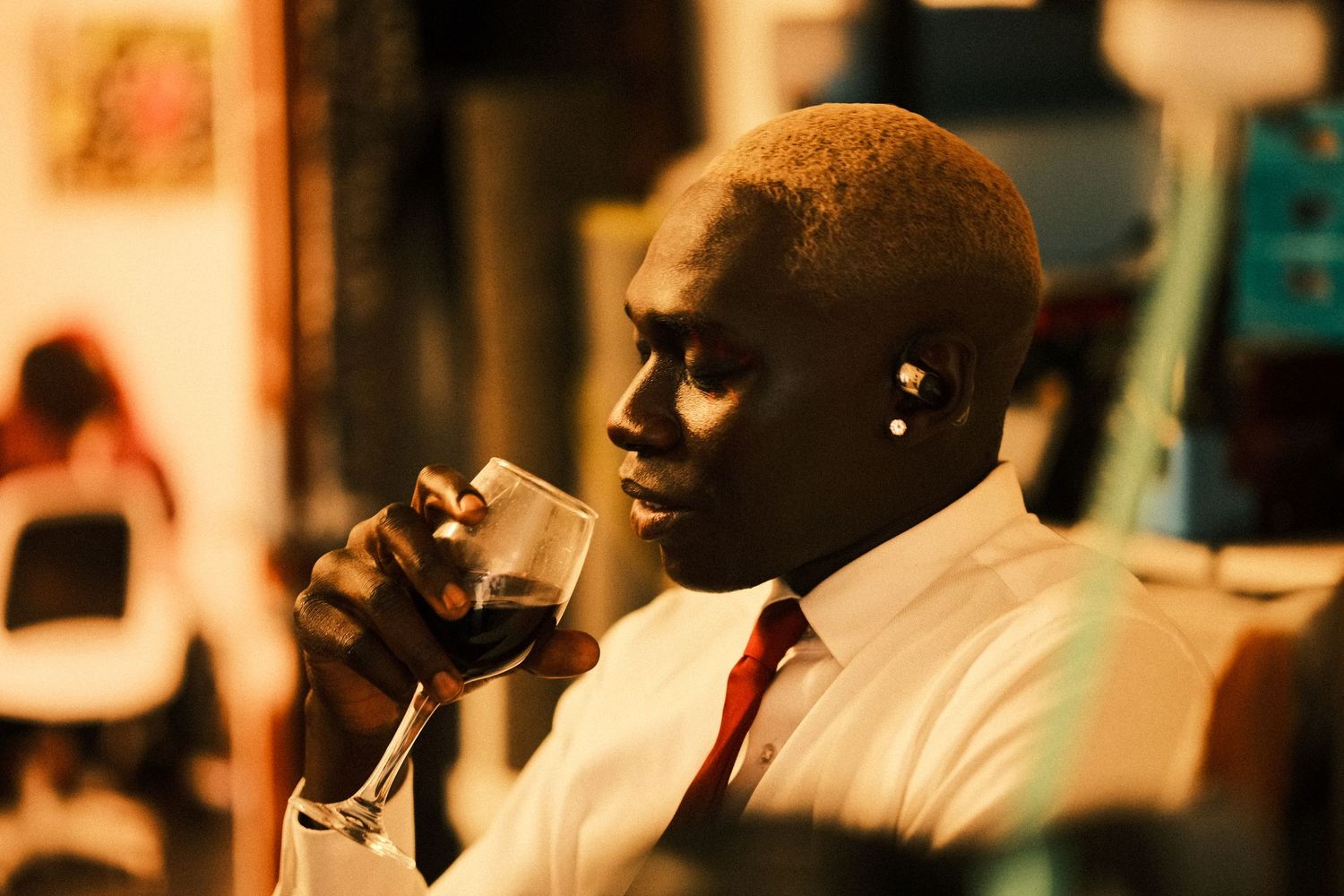 Atmospheric sepia-toned photograph of person in formal attire drinking from glass.