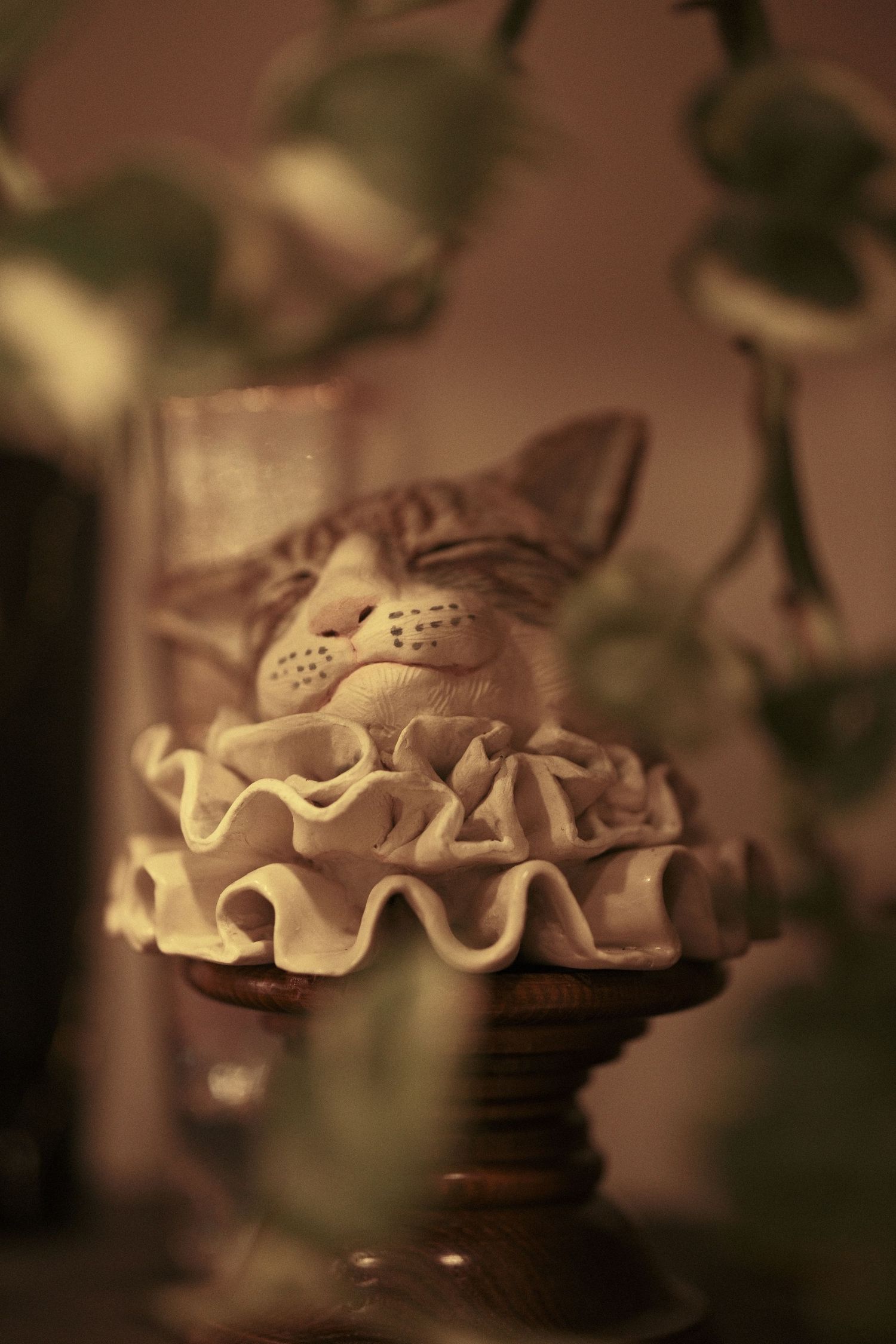A decorative pie or tart with ruffled edges displayed on an elegant cake stand.