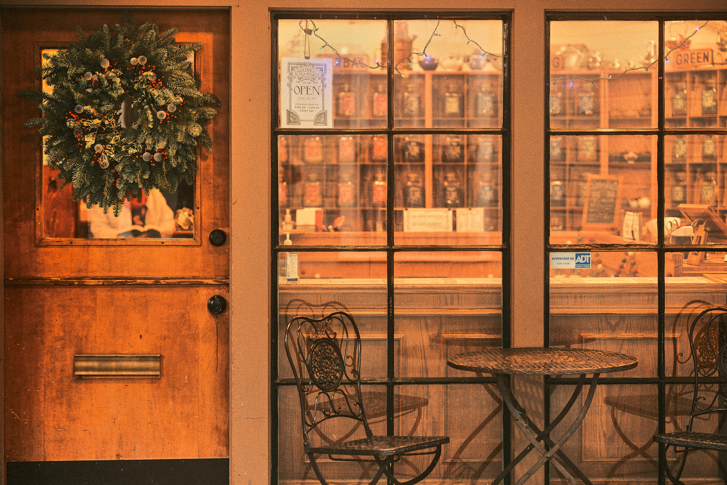 Orange-tinted storefront windows reflecting warm interior lighting at sunset.