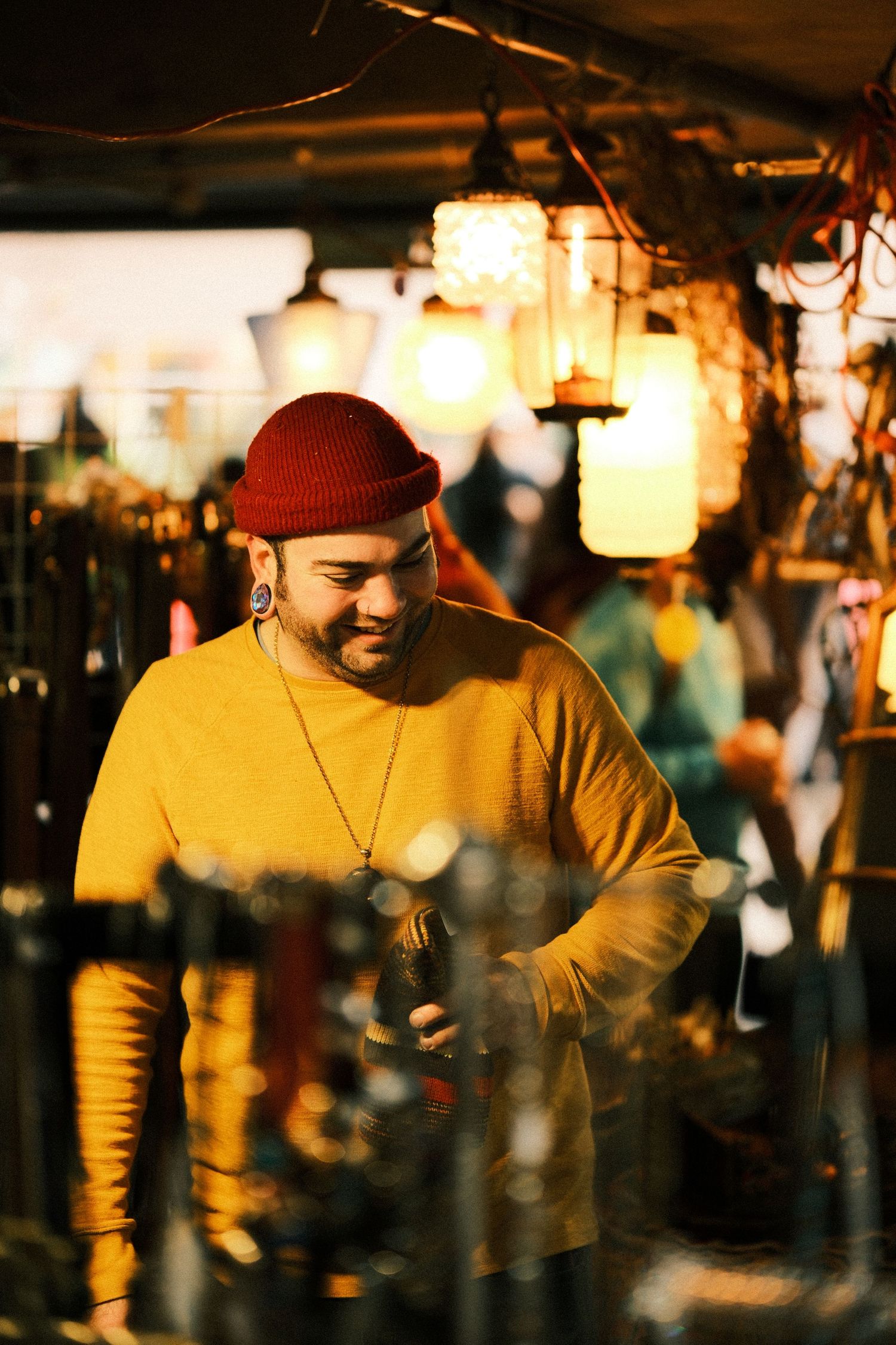 Person in red cap and yellow sweater captured in warm evening light with bokeh effects.