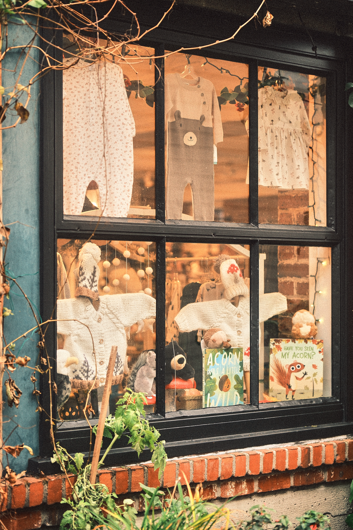 Decorated shop windows with holiday displays and brick exterior in warm afternoon light.