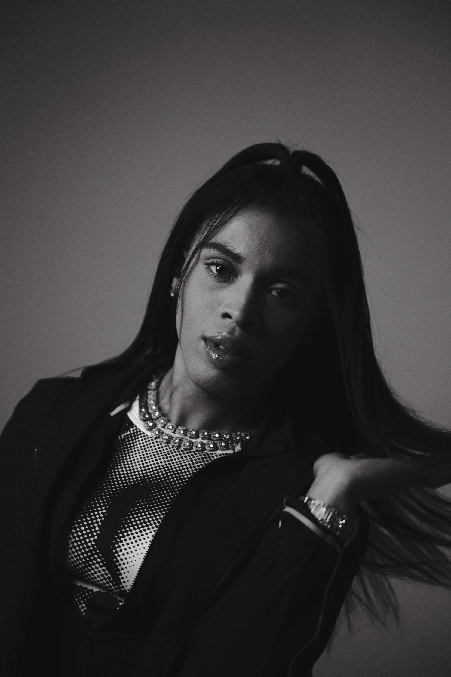 Dramatic black and white fashion portrait with jewelry and mesh details.