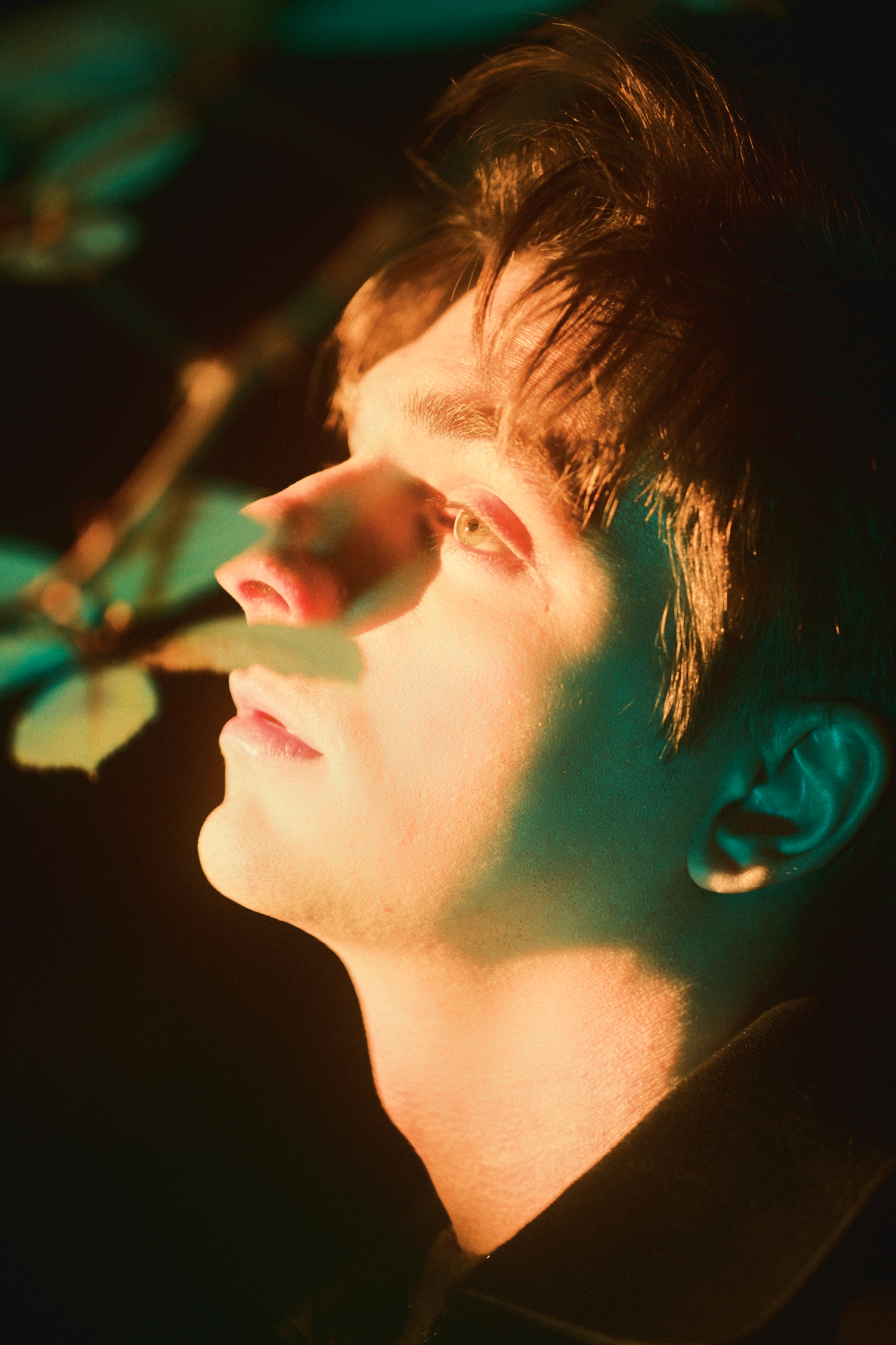 Artistic profile shots with green and amber lighting creating a dreamy cinematic atmosphere.