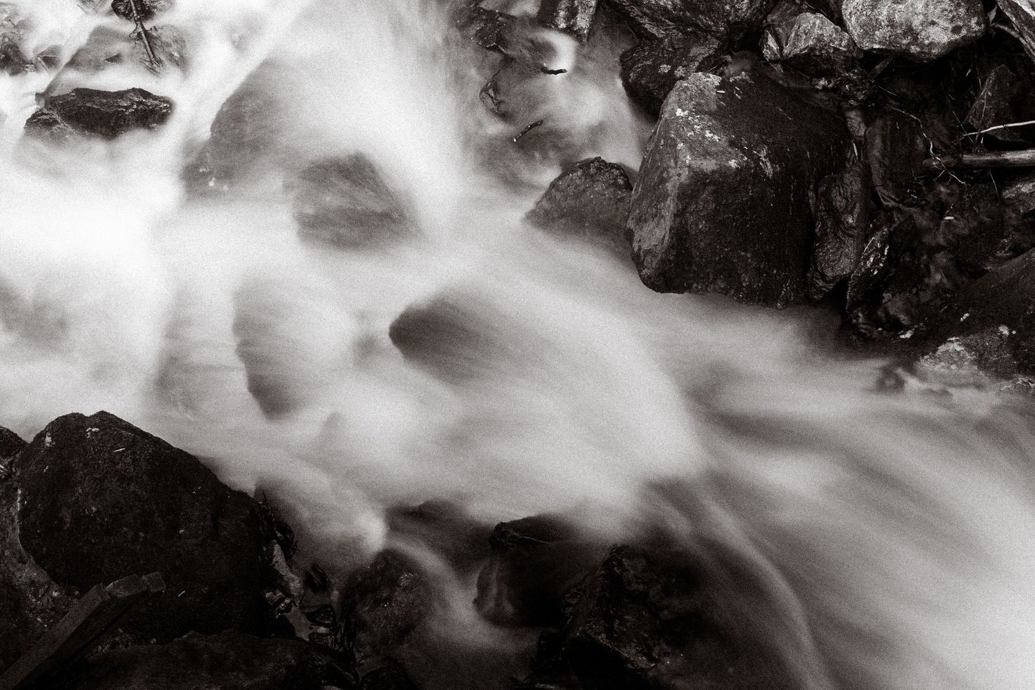 Long exposure waterfall creating smooth flowing water effects in black and white.