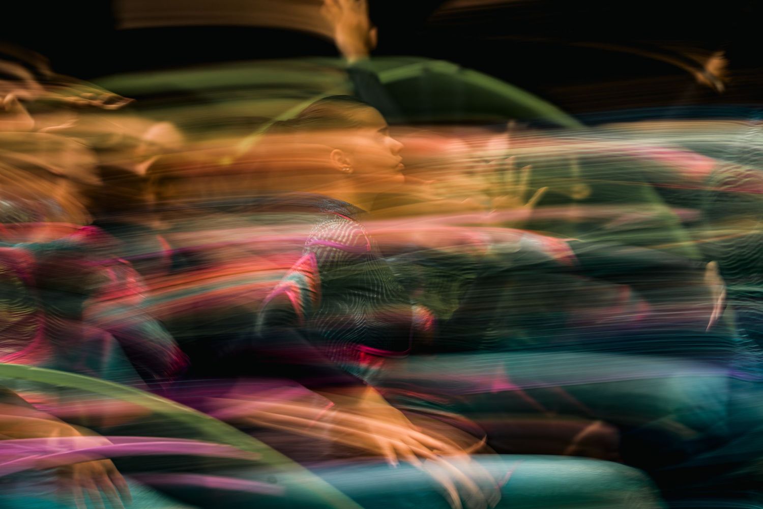 Abstract motion blur of colorful cars in traffic, creating a vibrant streaked light effect at night.