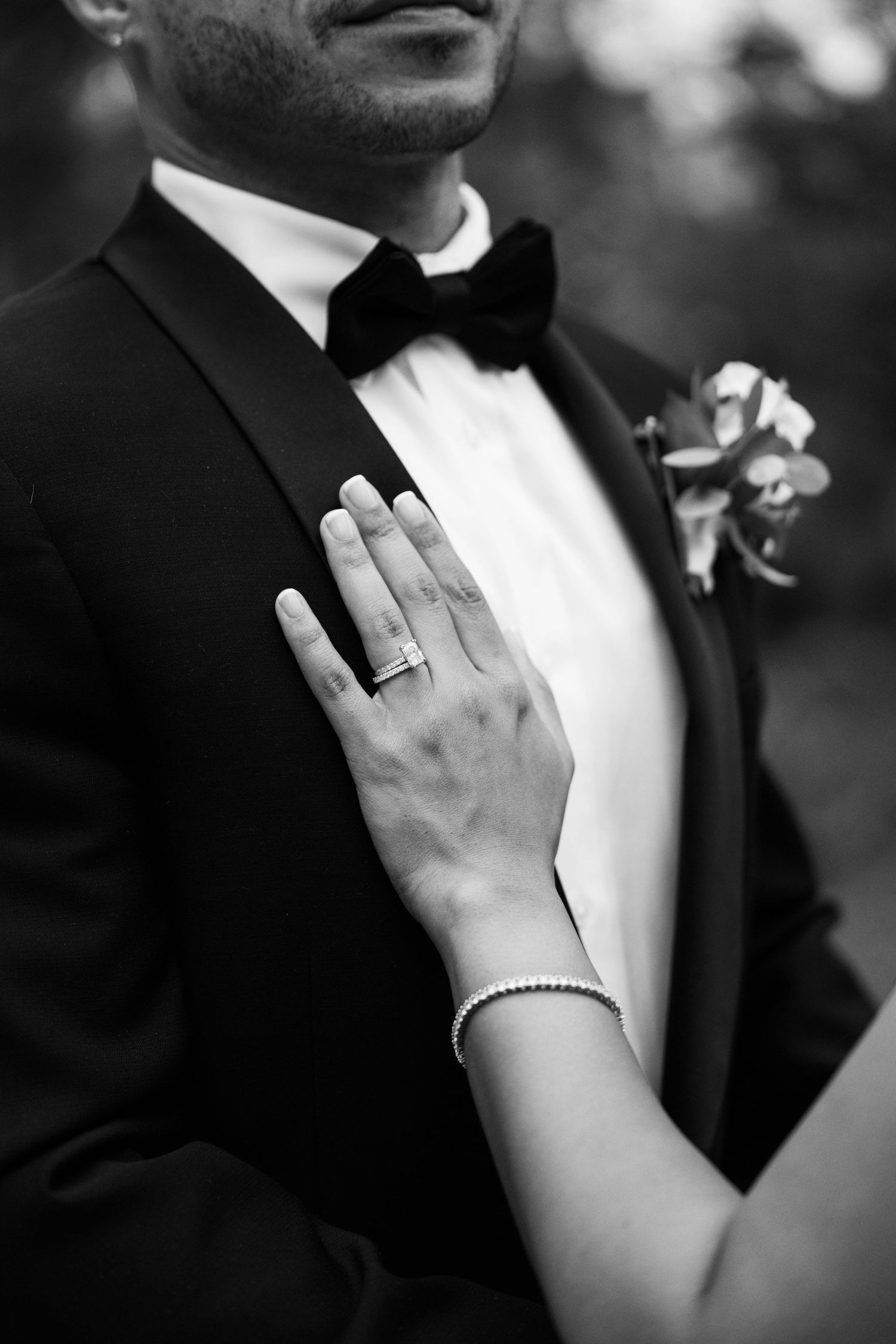 Close-up black and white details of formal wedding attire and jewelry.