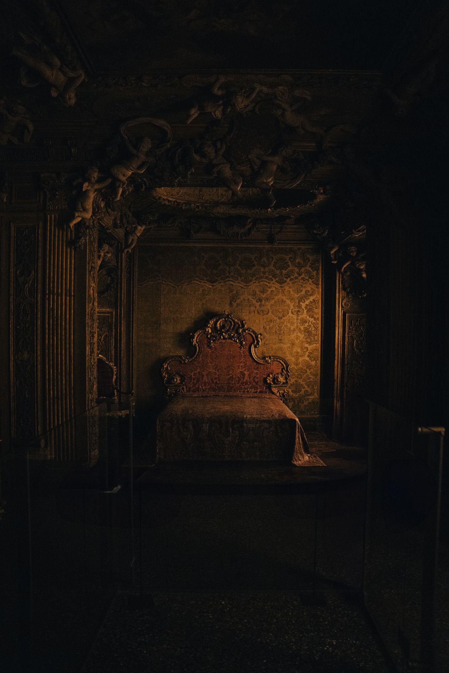 Dark ornate theater or palace interior with decorative architectural details.