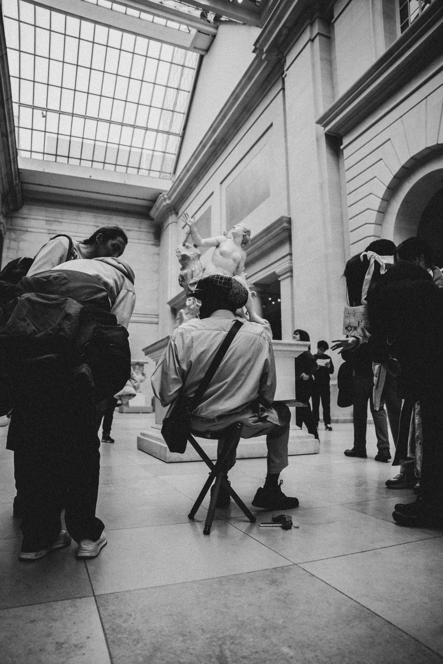 Dancers performing expressive movements in a grand hall with natural lighting.