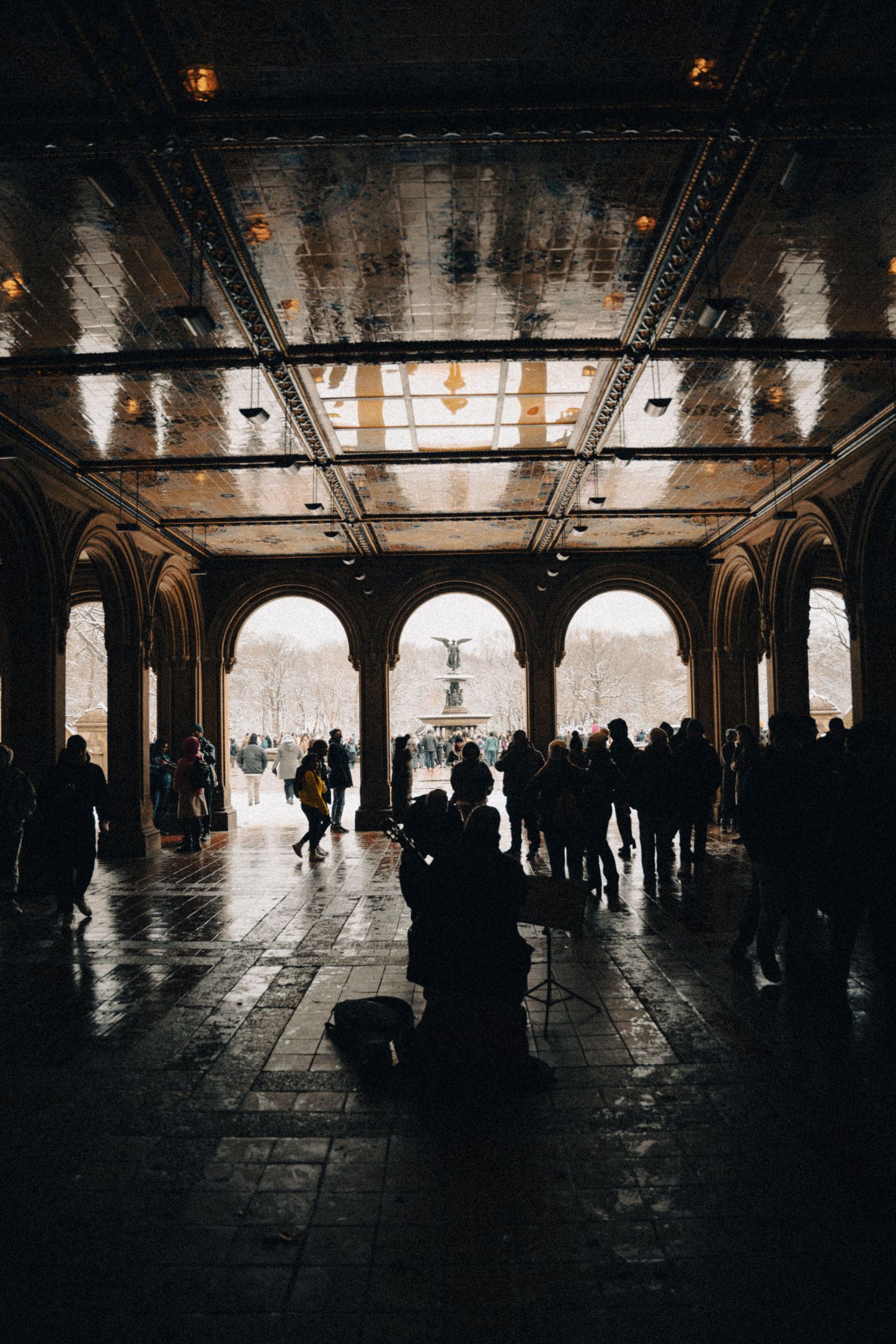 Silhouetted figures in historic archway with dramatic backlighting creating atmospheric scene.