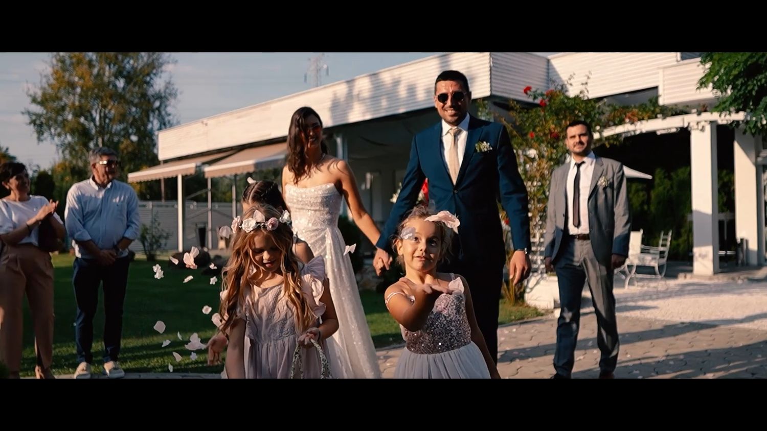 Wedding party walking and laughing together on outdoor pathway during celebration.
