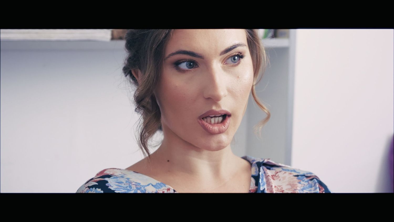 Close up portrait of person with dramatic makeup and floral dress.