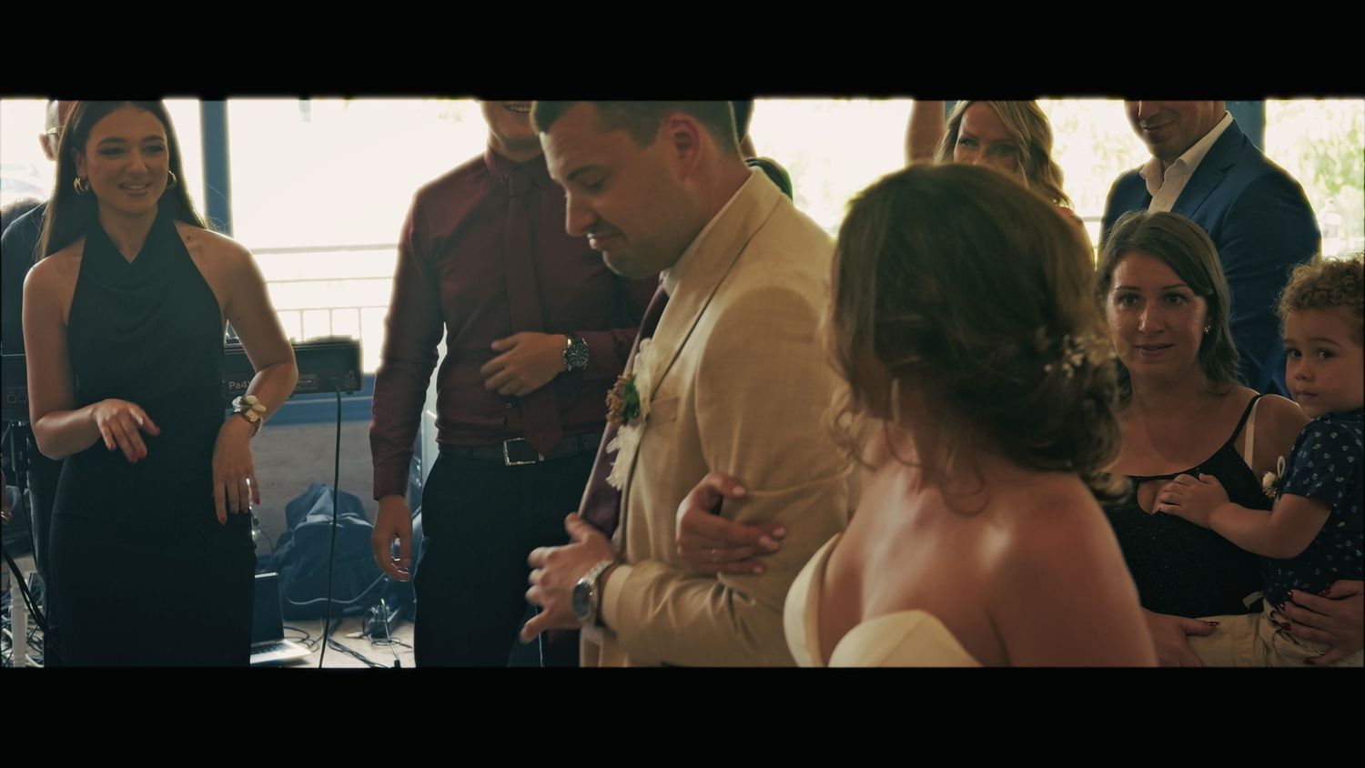 Wedding guests gather around during an intimate celebration moment.