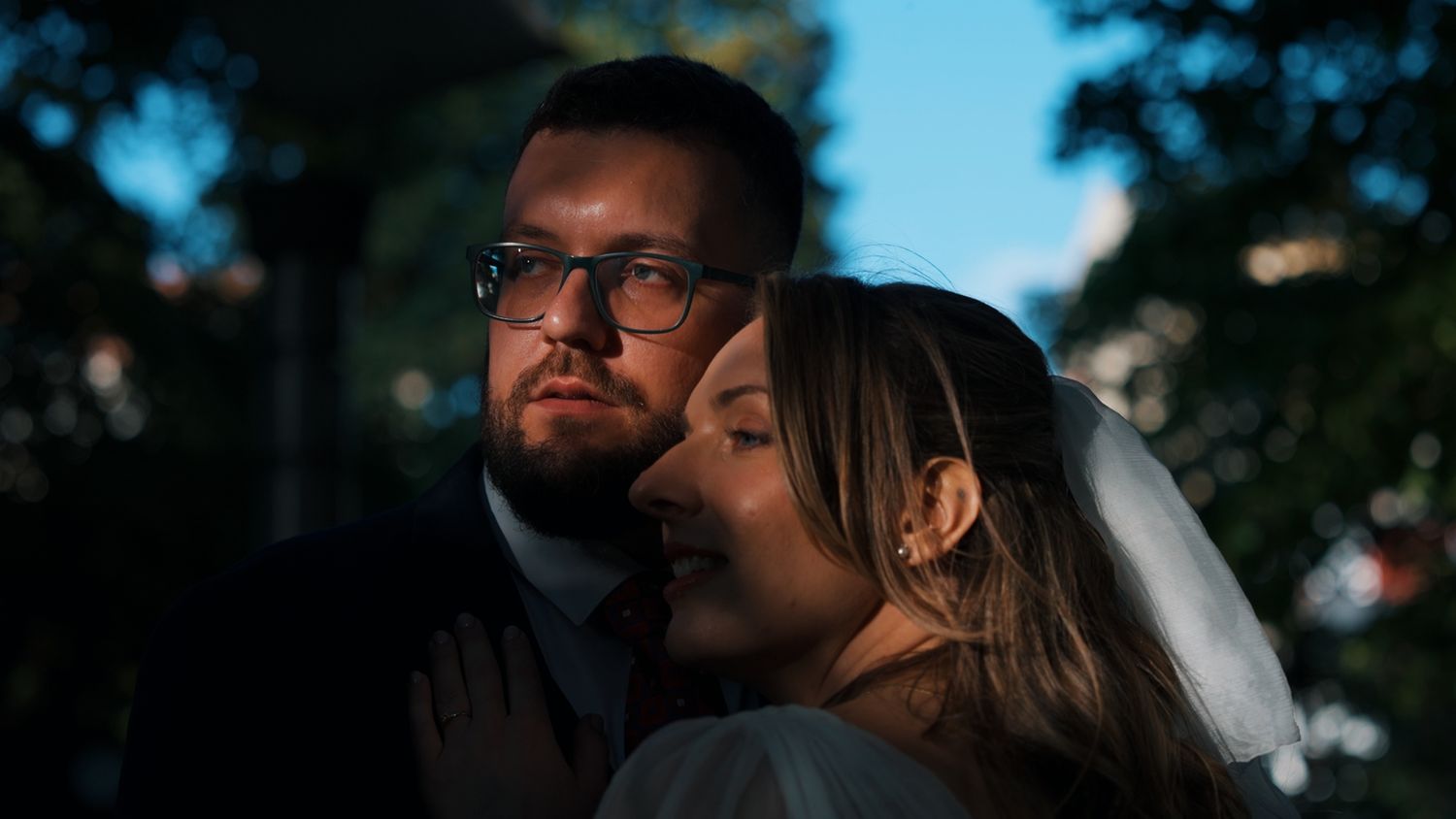 Romantic sunset portrait through trees with blue sky background.