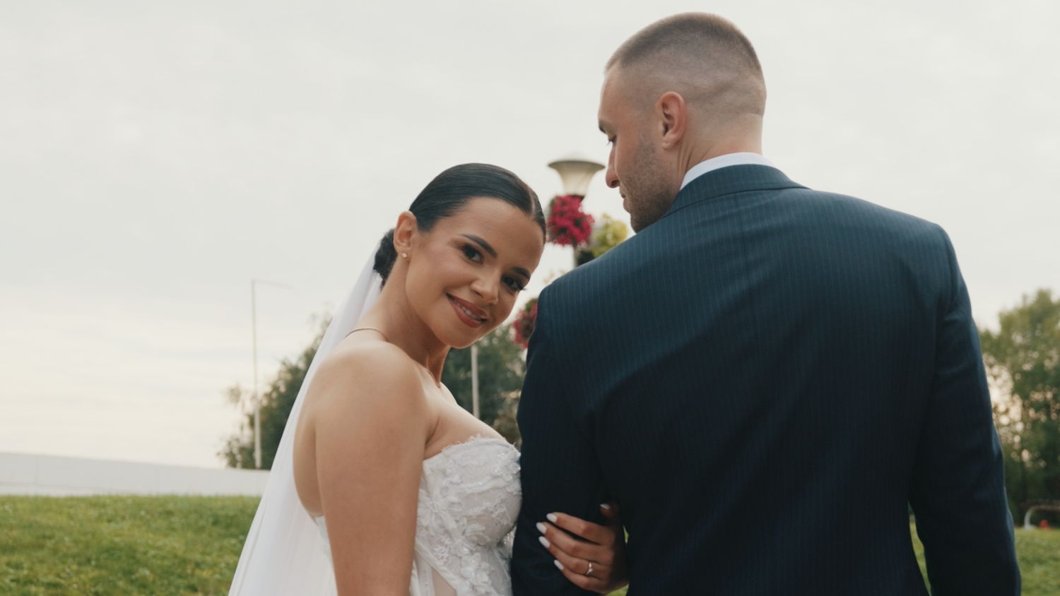 Newlyweds share an intimate embrace on their wedding day outdoors.