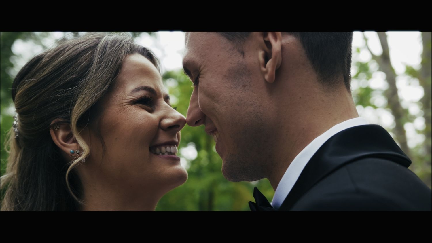Intimate close-up of couple sharing romantic moment during outdoor wedding.