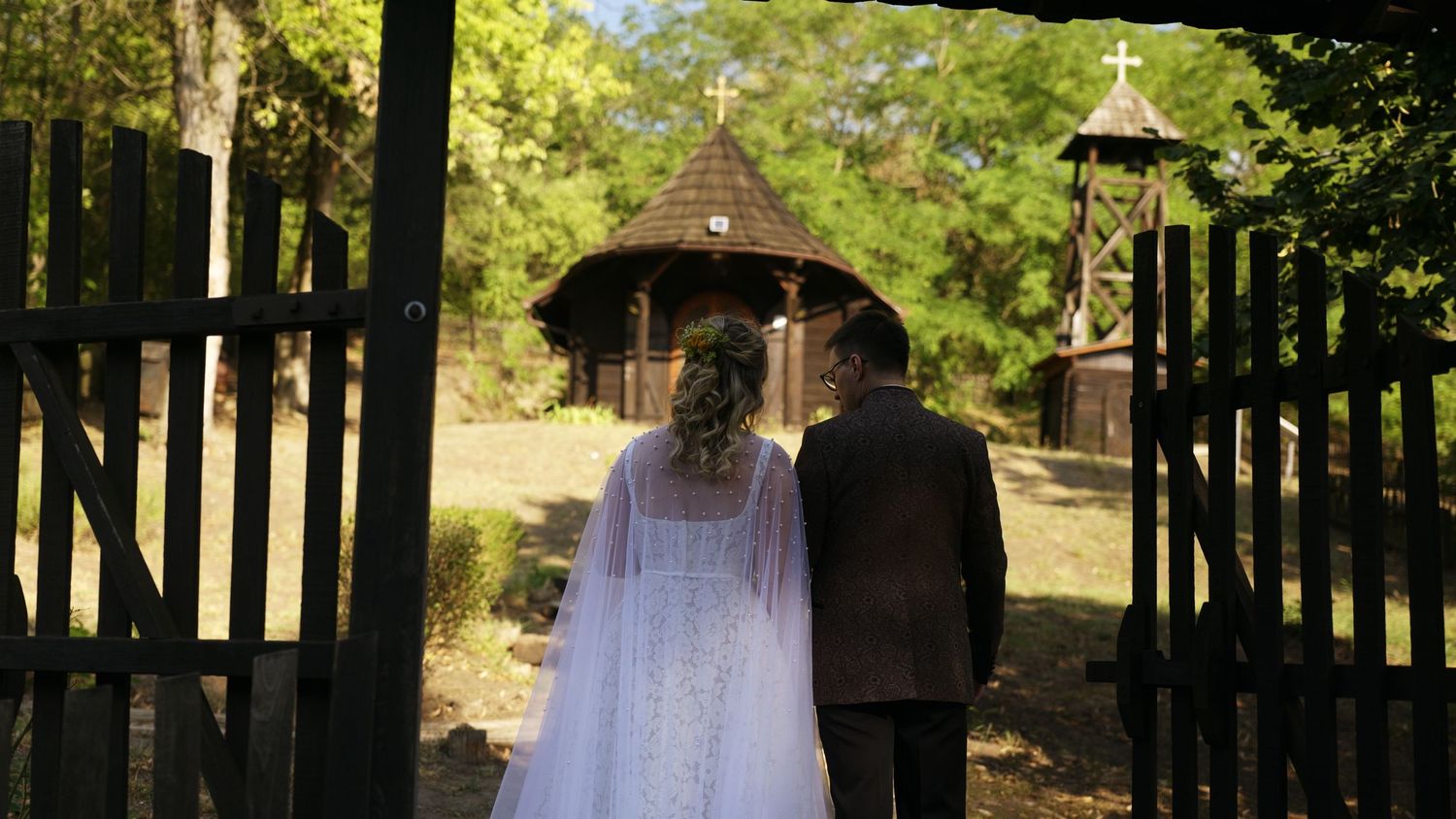 Church entrance path lined with trees and iron gates leading to ceremony site.