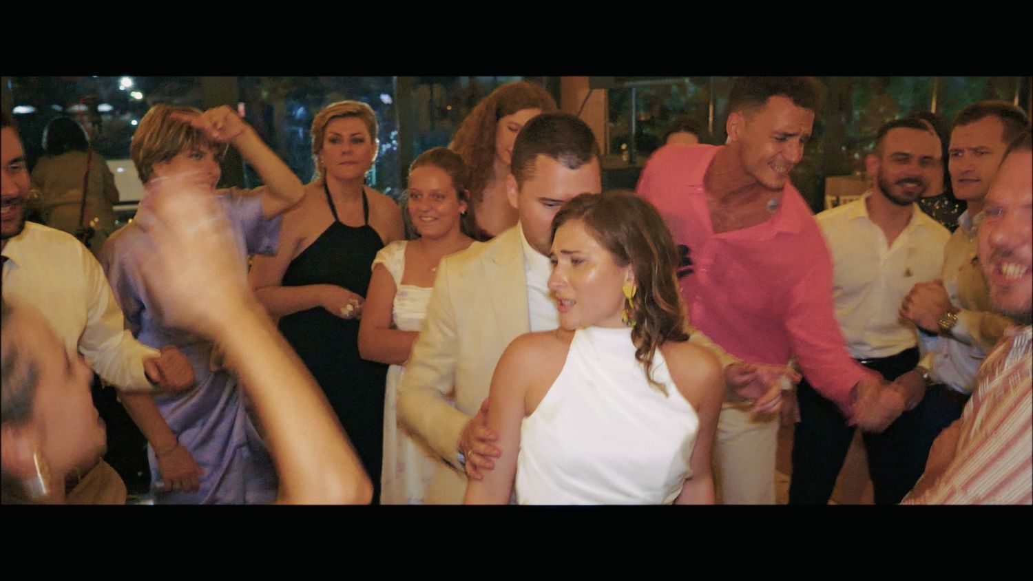 Crowded dance floor with party guests enjoying themselves under twinkling lights.