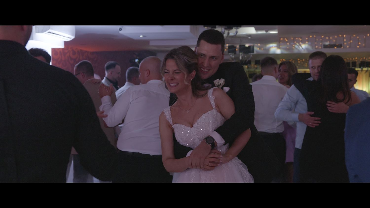 Wedding guests dancing together during a lively reception celebration.