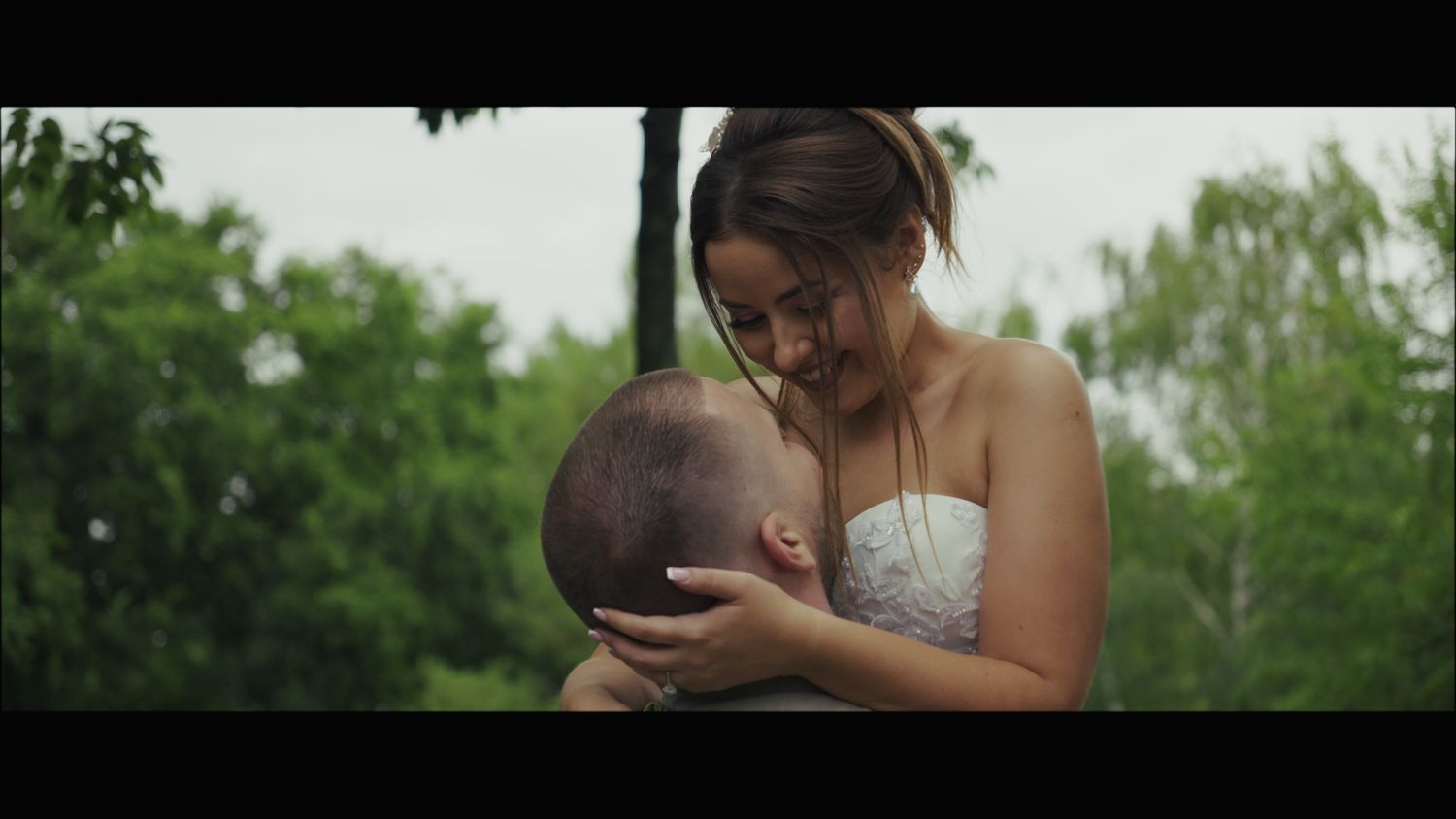 Romantic wedding couple sharing tender moment in garden setting.