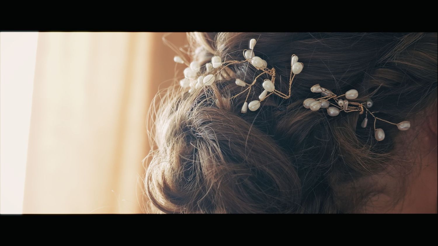 Delicate pearl hair accessory detail in bridal hairstyle.