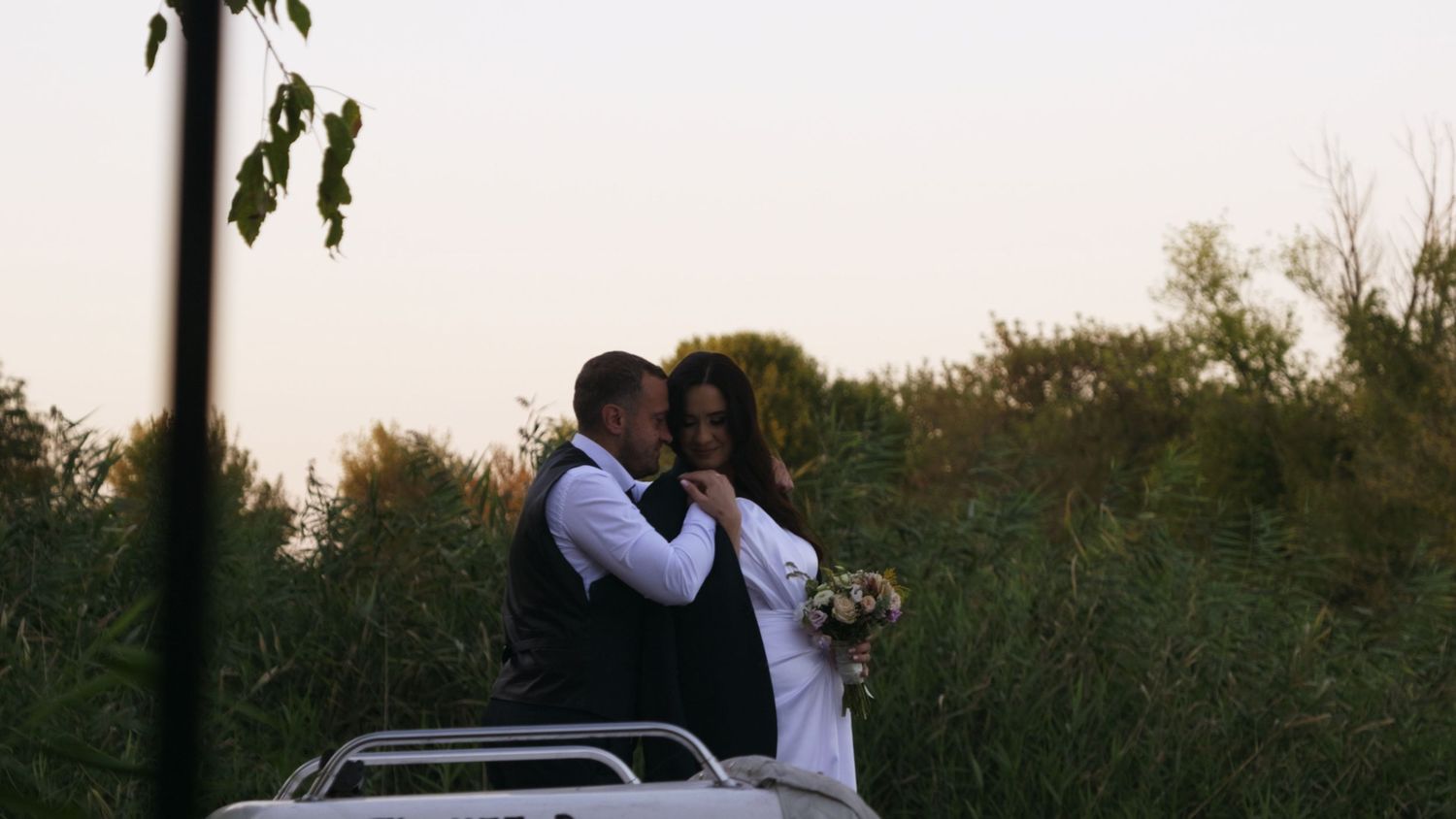 Romantic outdoor wedding scene with natural sunset lighting.