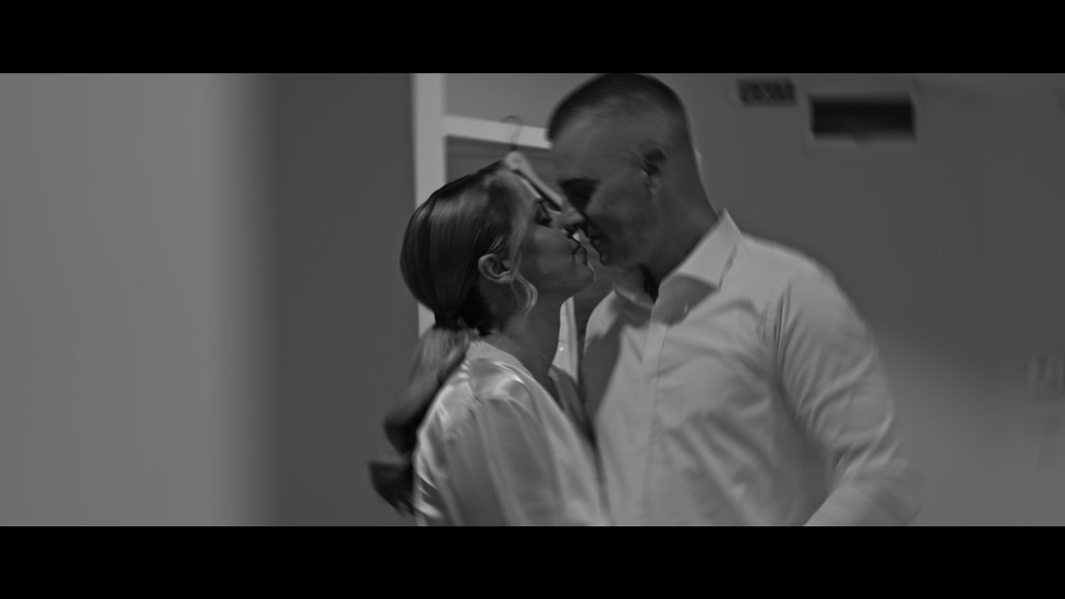 Black and white photo of two people in an intimate pose.