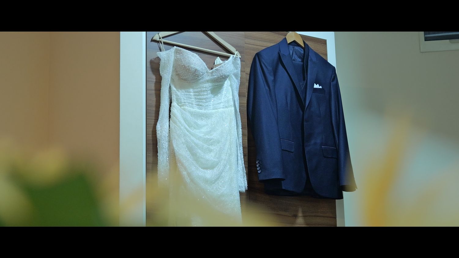 Wedding attire hanging neatly on display in a bright room.