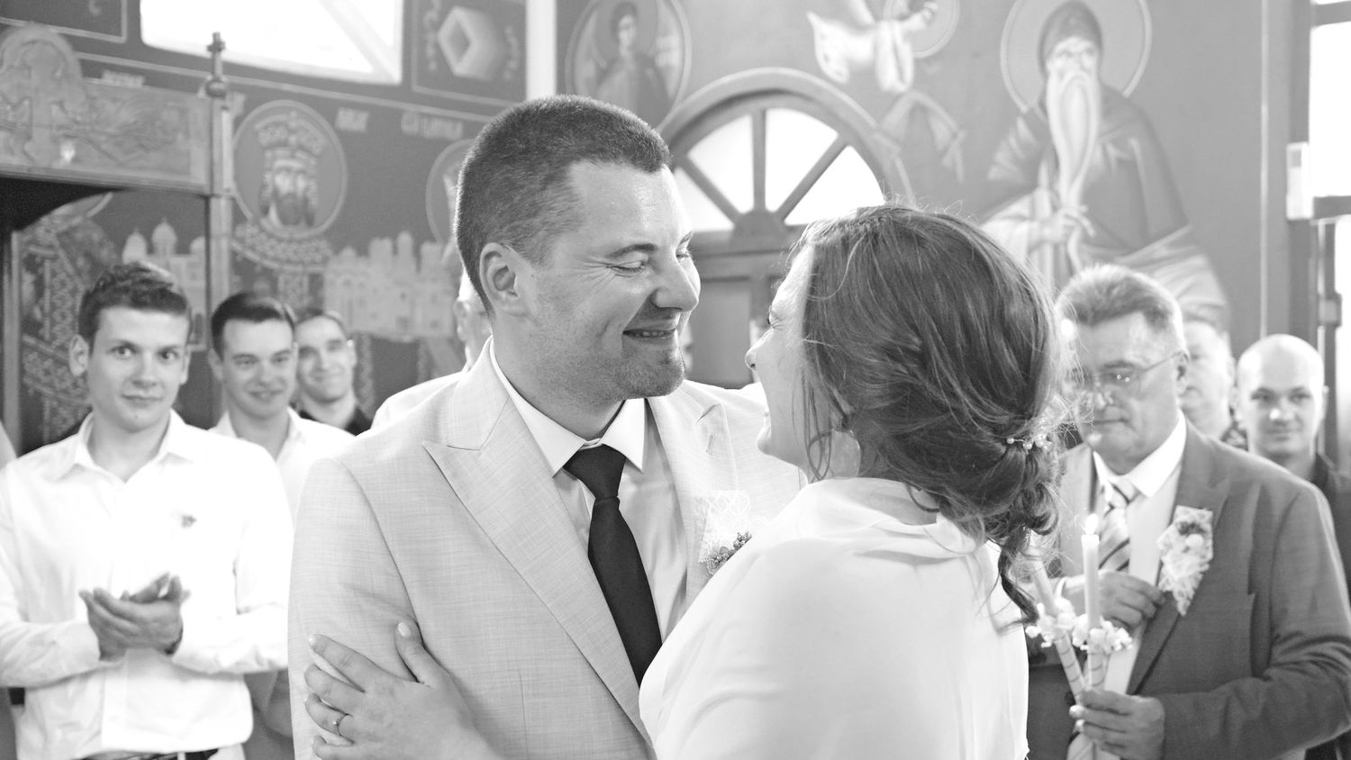 Wedding reception guests dance and celebrate in black and white photography.