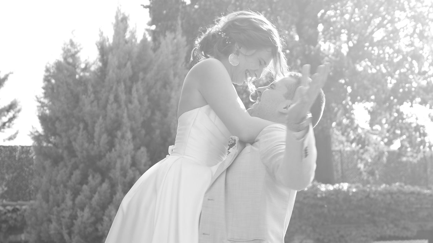 Black and white photo of wedding guests celebrating outdoors.