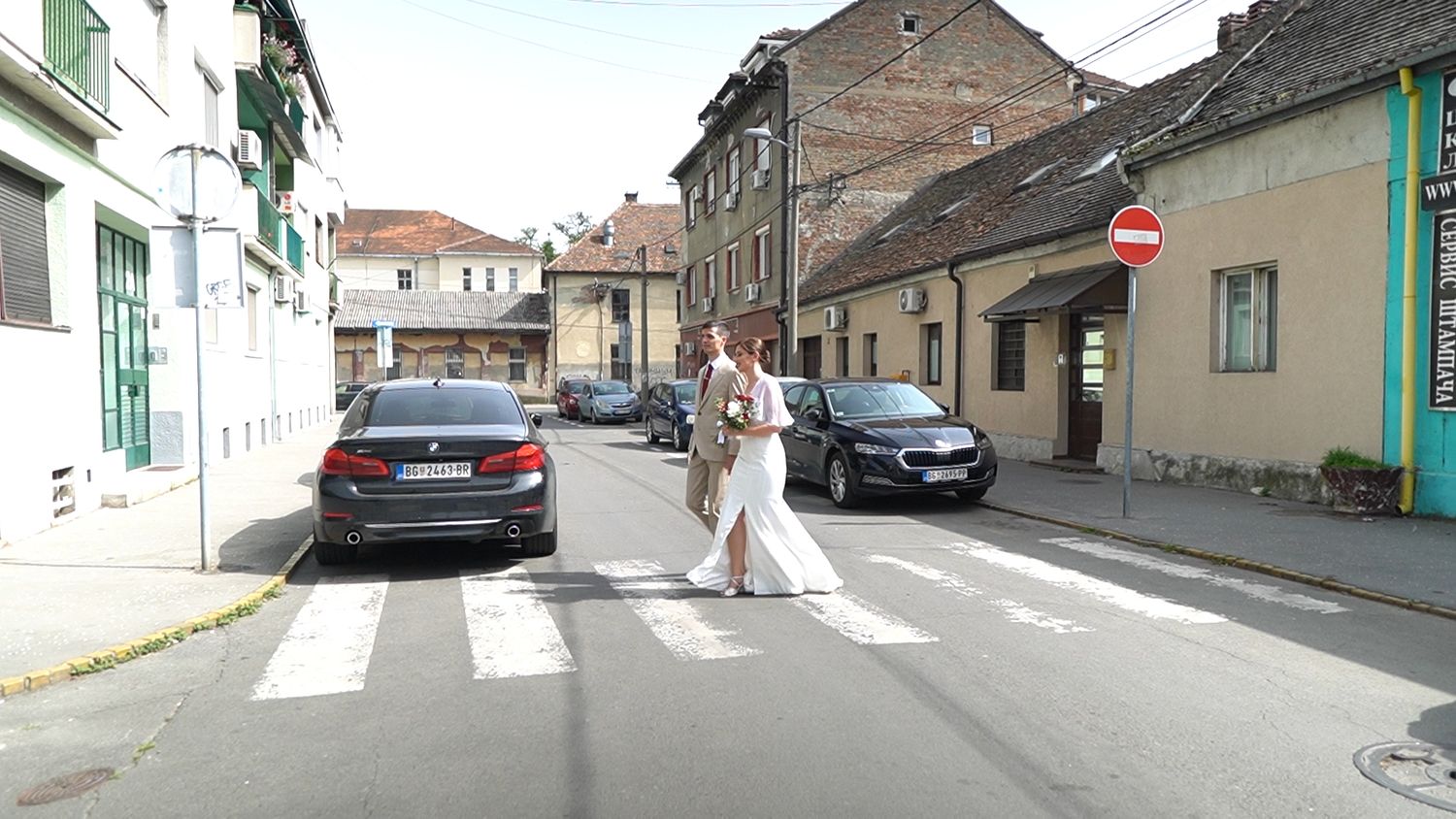 Empty European street with historic buildings and parked cars.