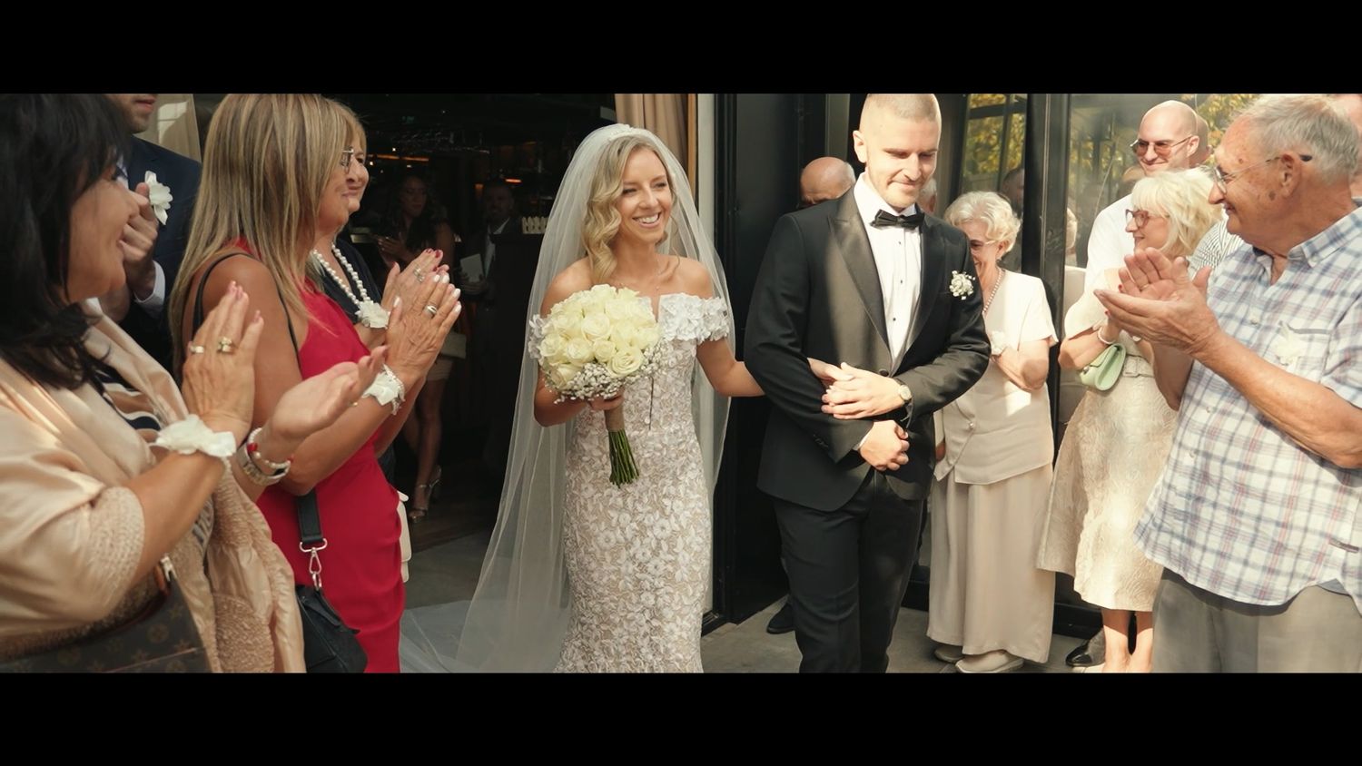 Wedding reception scene with guests celebrating in an elegant venue.