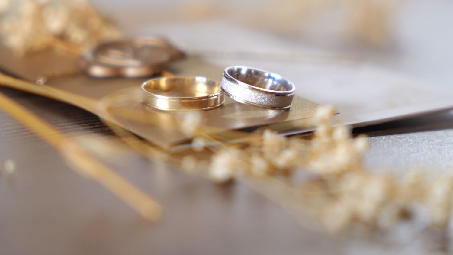Wedding rings displayed on a textured surface with shallow depth of field.