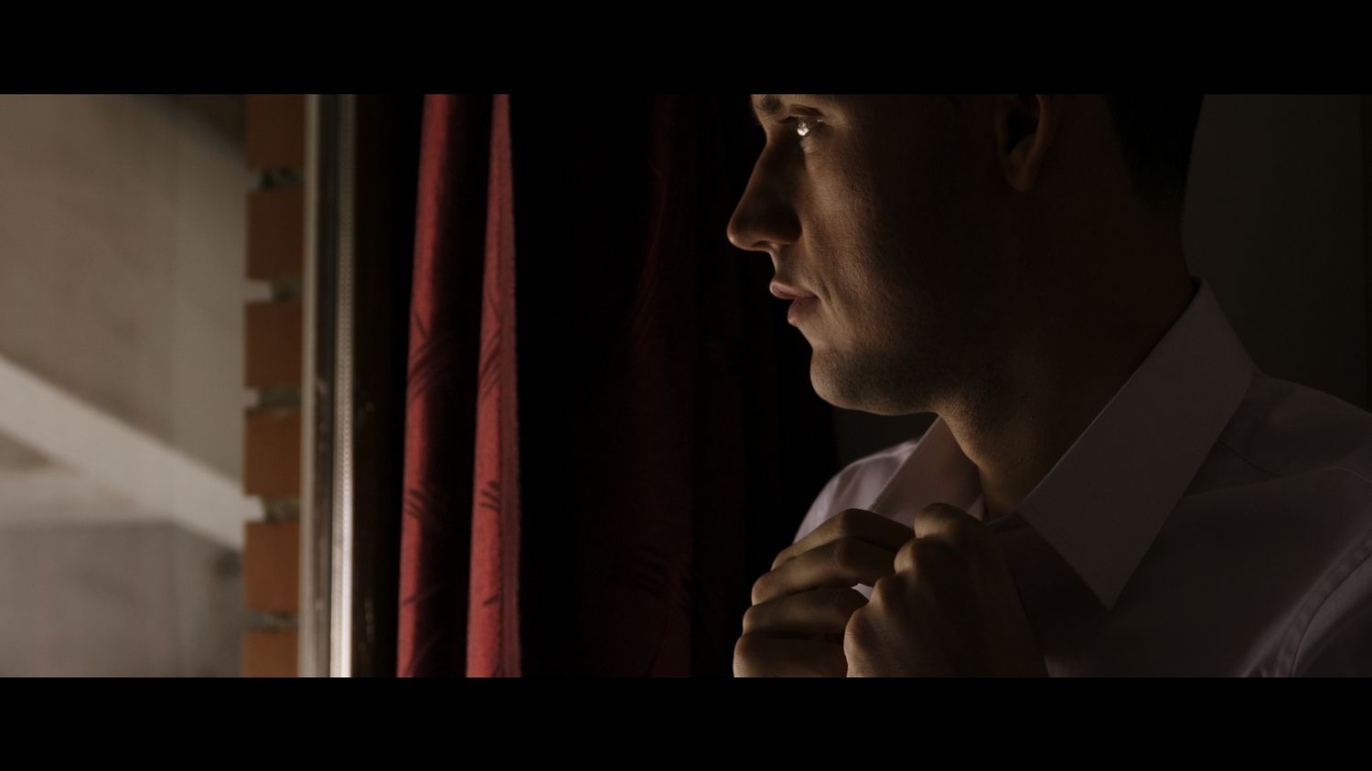 A couple shares an intimate moment in a dimly lit setting during their wedding celebration.