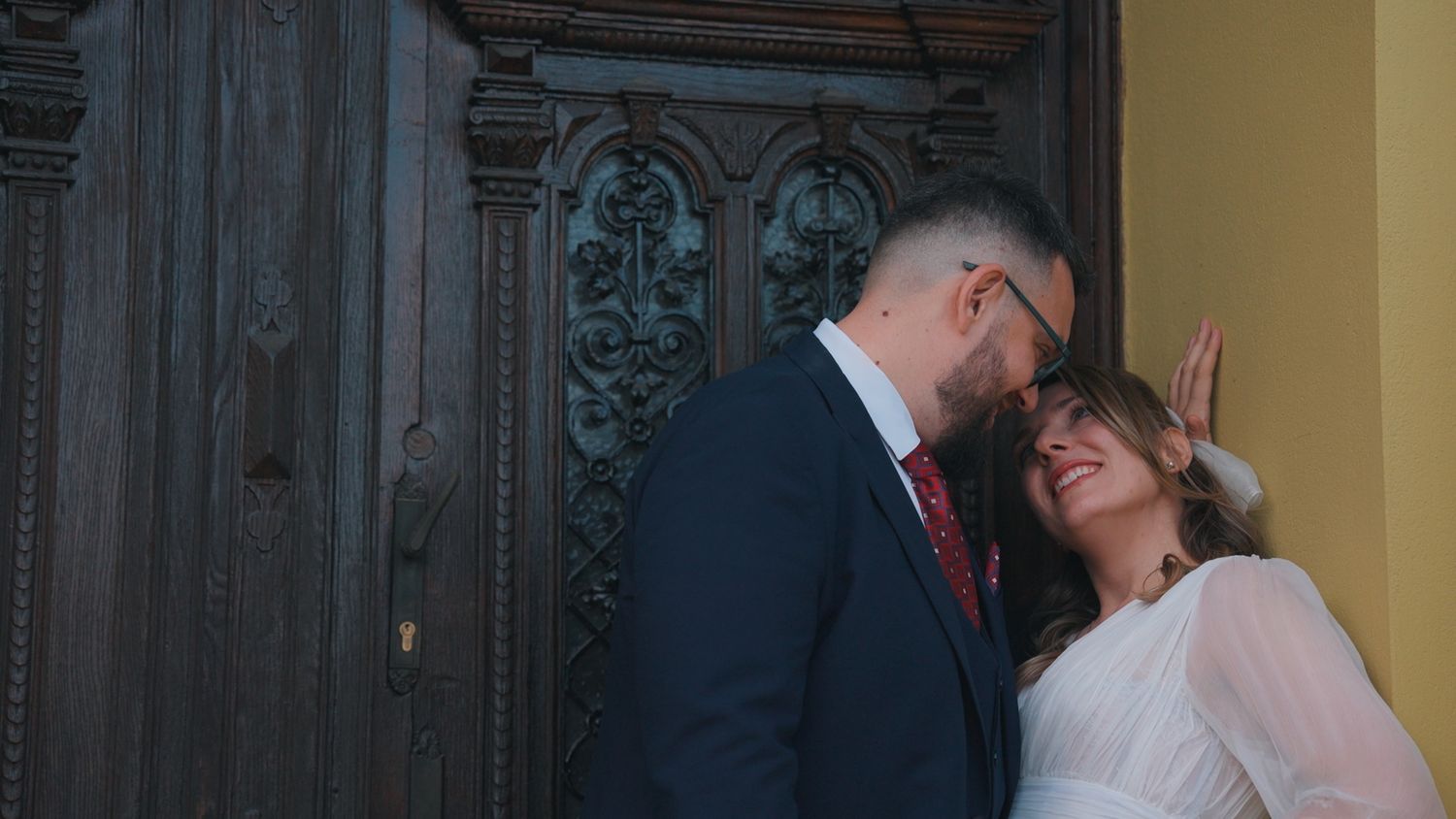 Ornate wooden door frame in an elegant venue setting with yellow walls.