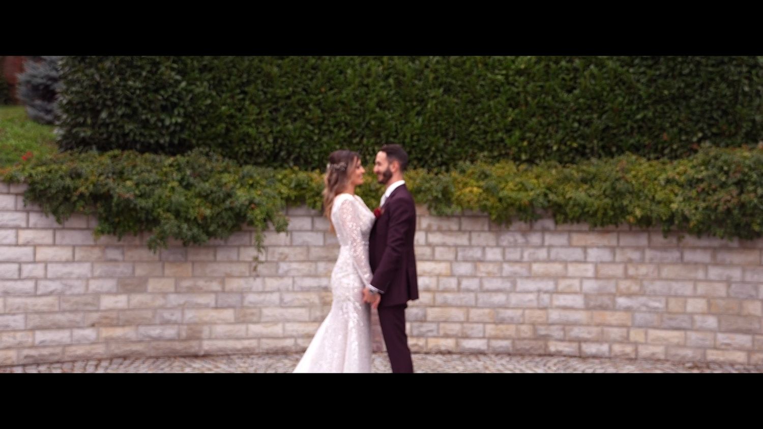 Elegant wedding ceremony setup with white chairs and floral decorations in an outdoor garden setting.