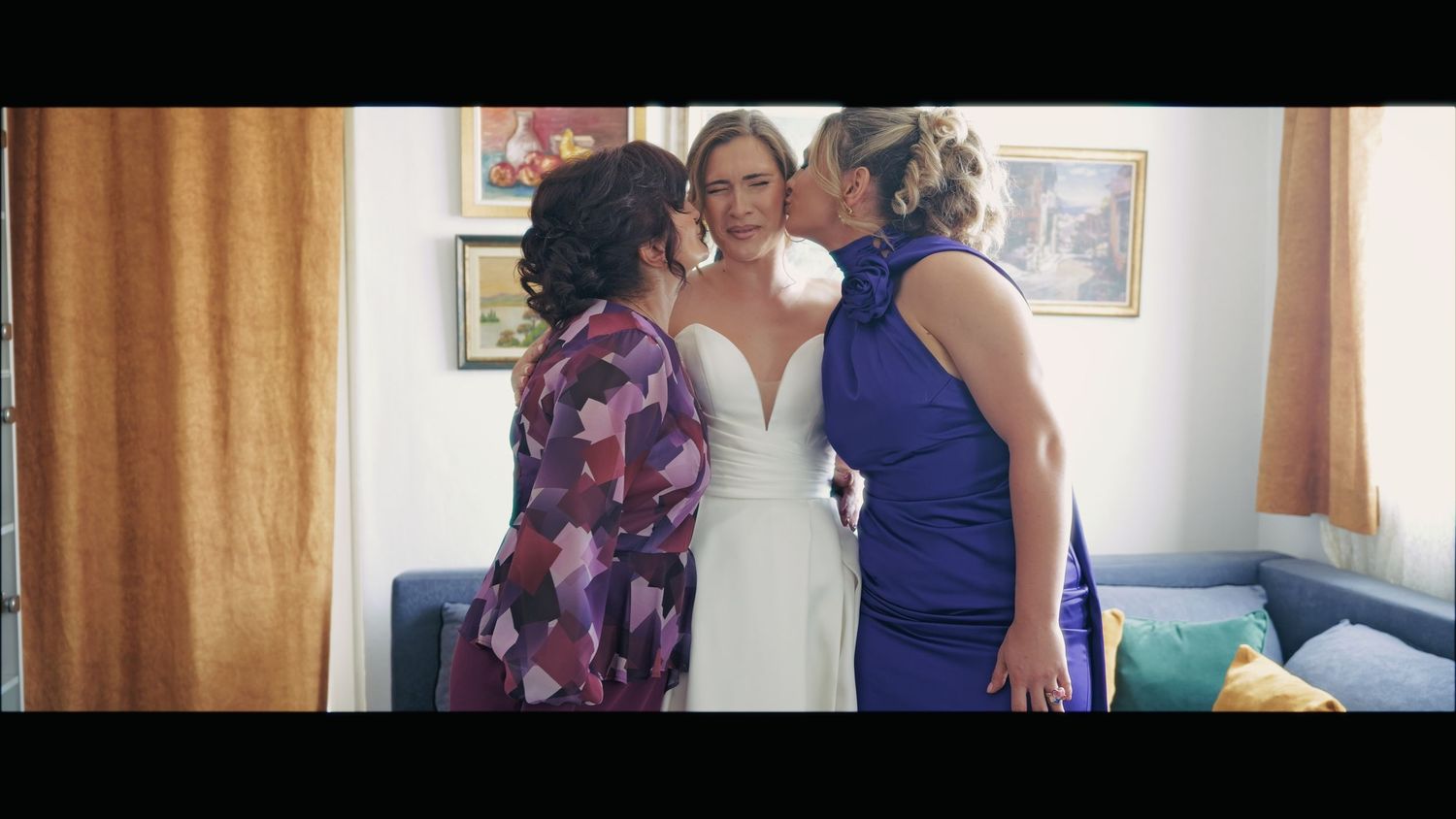 Bridesmaids in blue dresses share a joyful moment during wedding preparations.