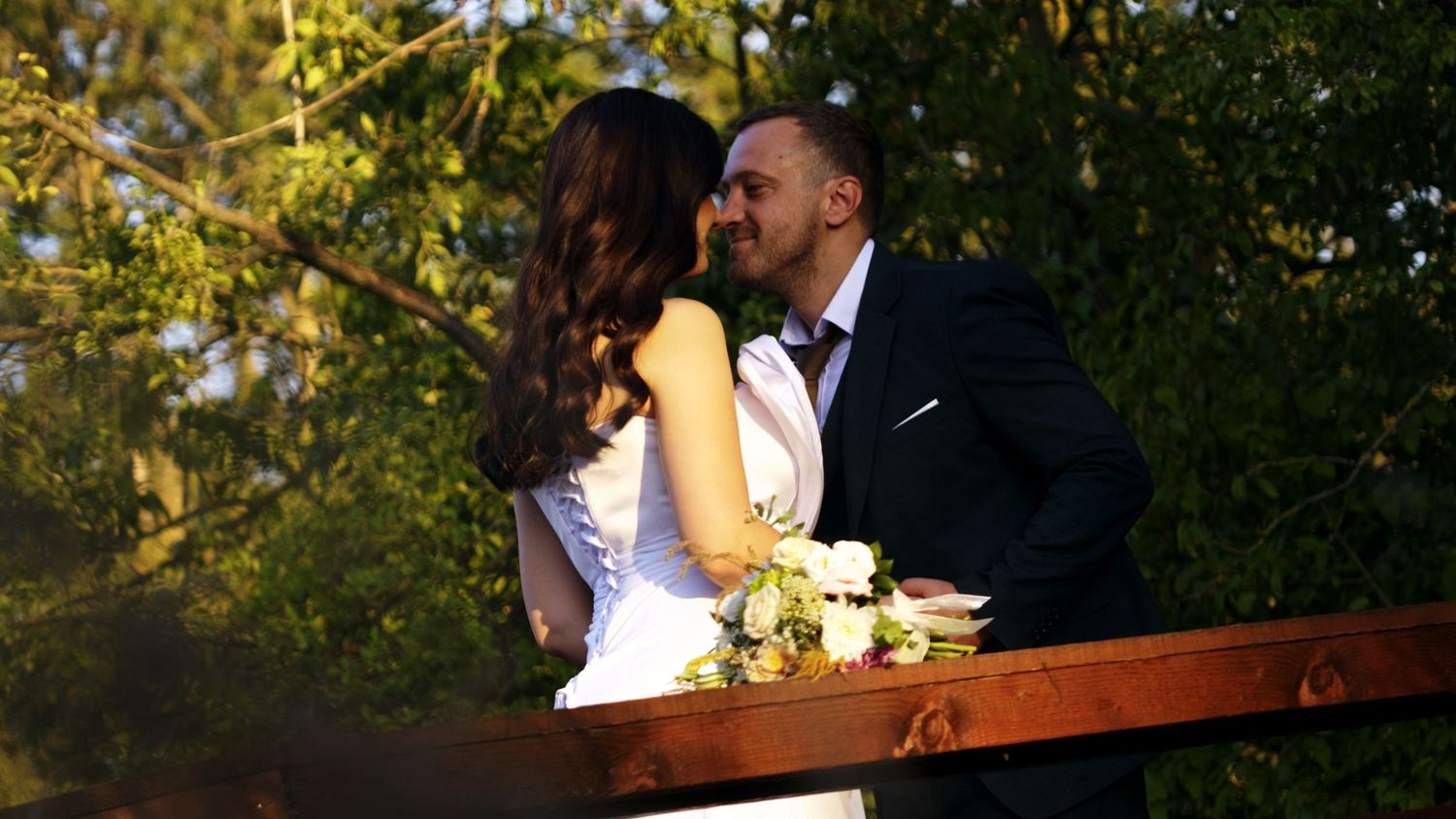 Outdoor wedding ceremony setup with natural greenery and golden sunlight.