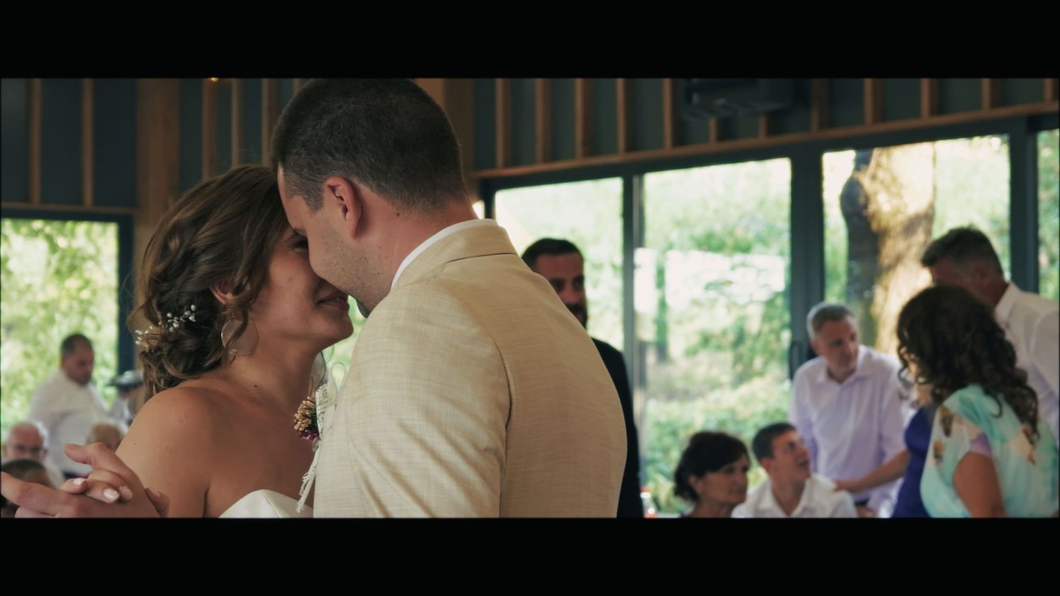 Wedding guests enjoying outdoor celebration under covered patio.