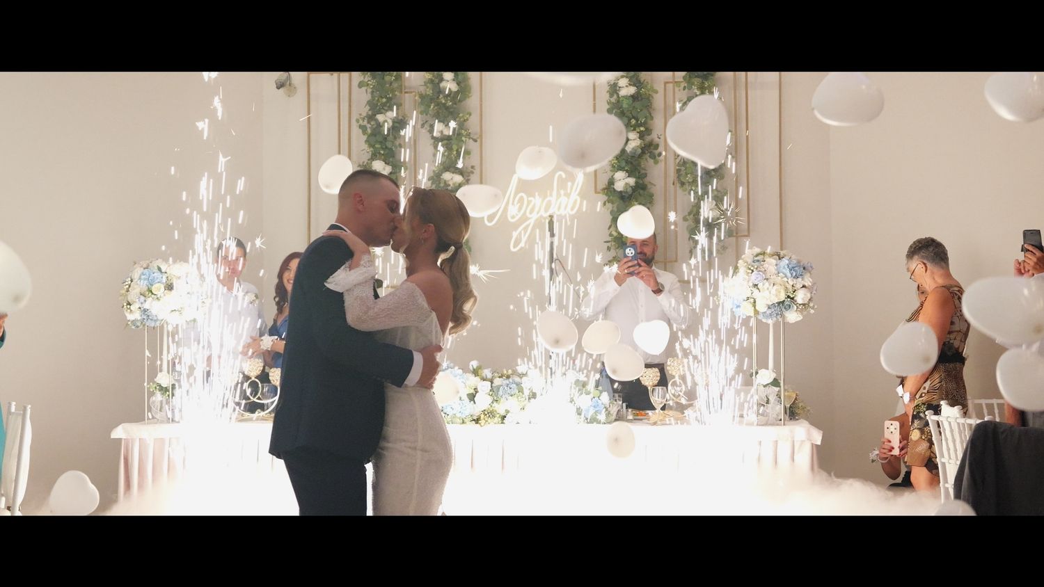 Wedding venue decorated with hanging crystal chandeliers and white drapery.