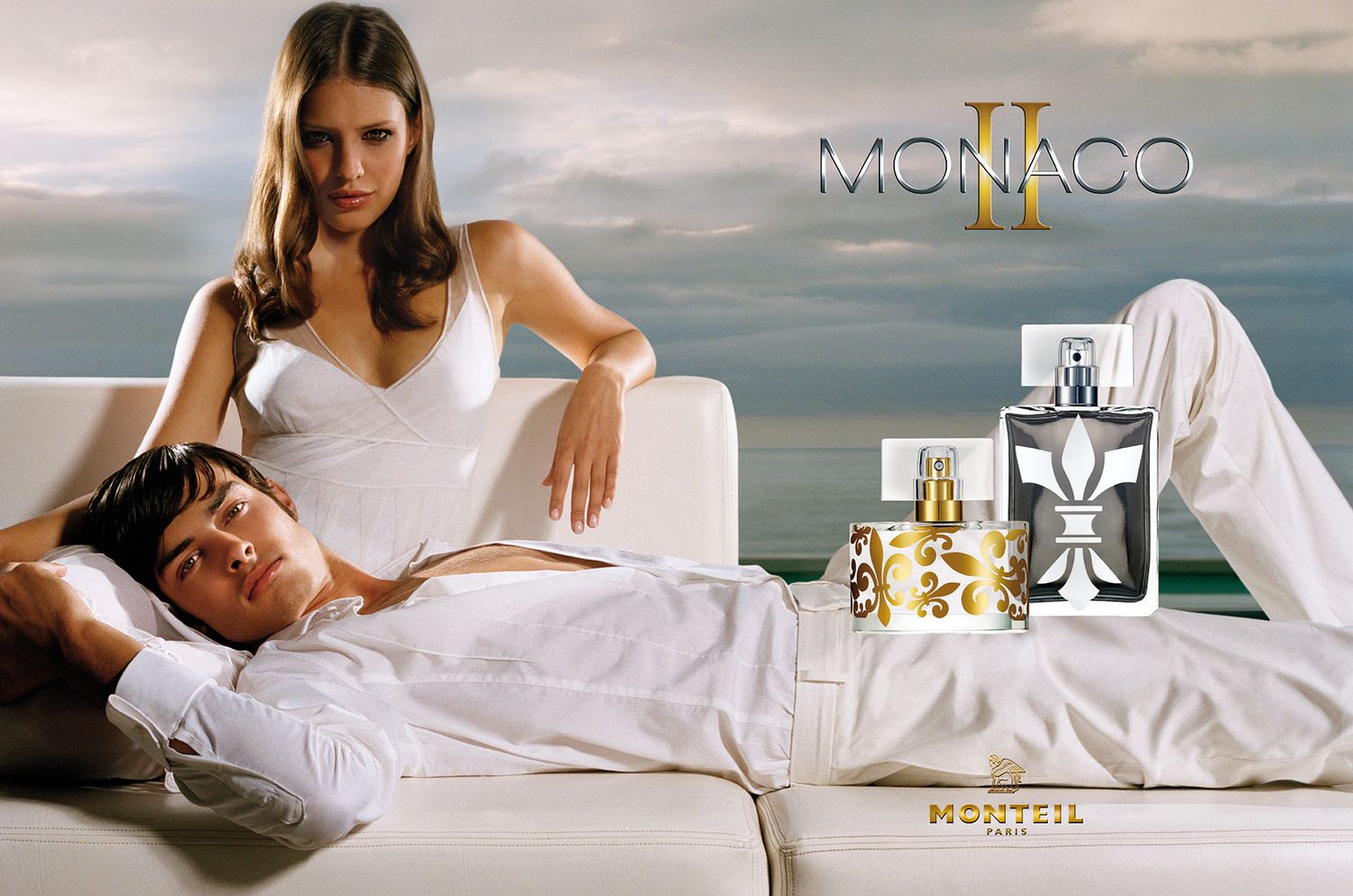 Monaco perfume campaign features white bedding and elegant fragrance bottles against coastal backdrop.