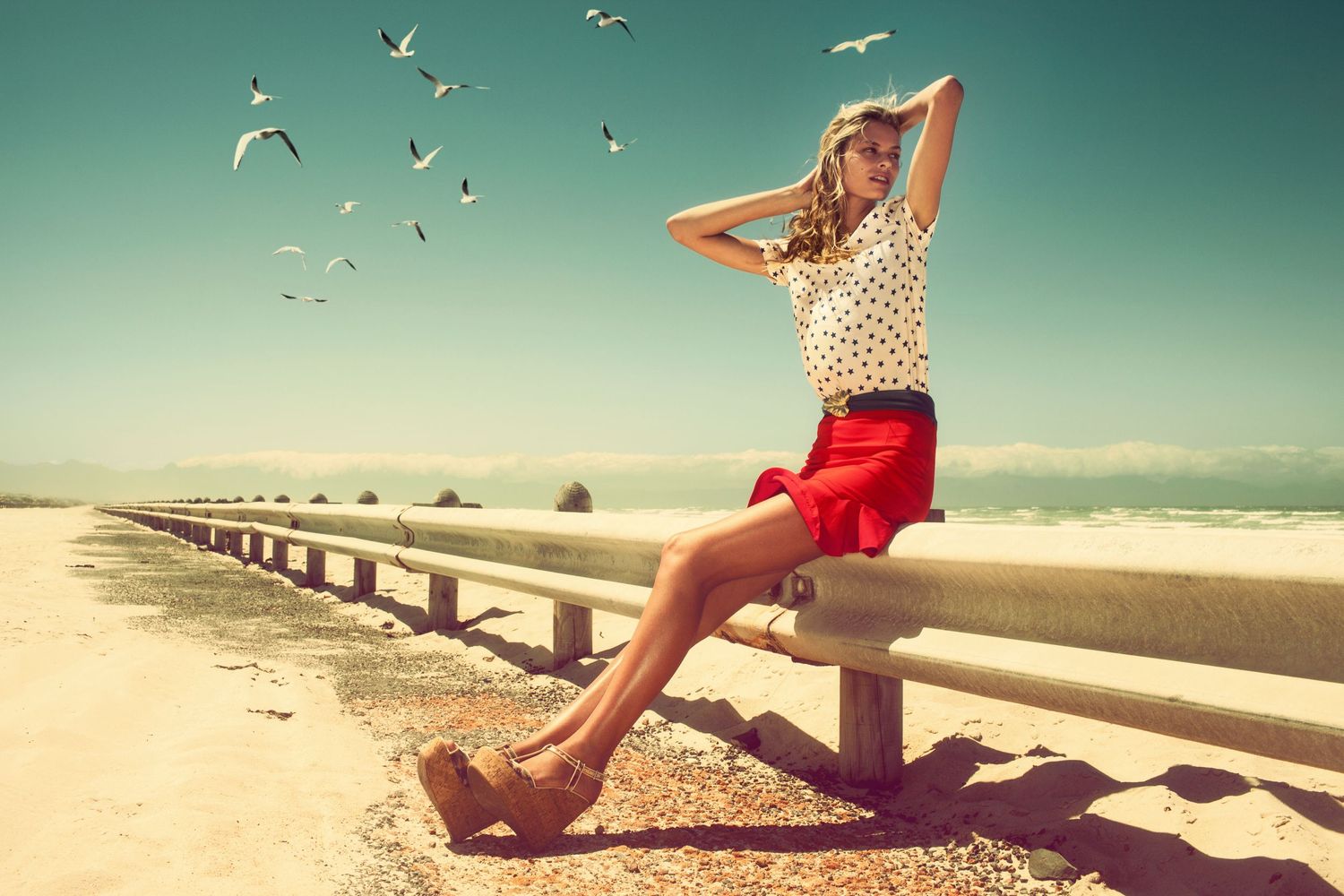 Seascape photography series with seagulls flying over a beach on a sunny summer day.