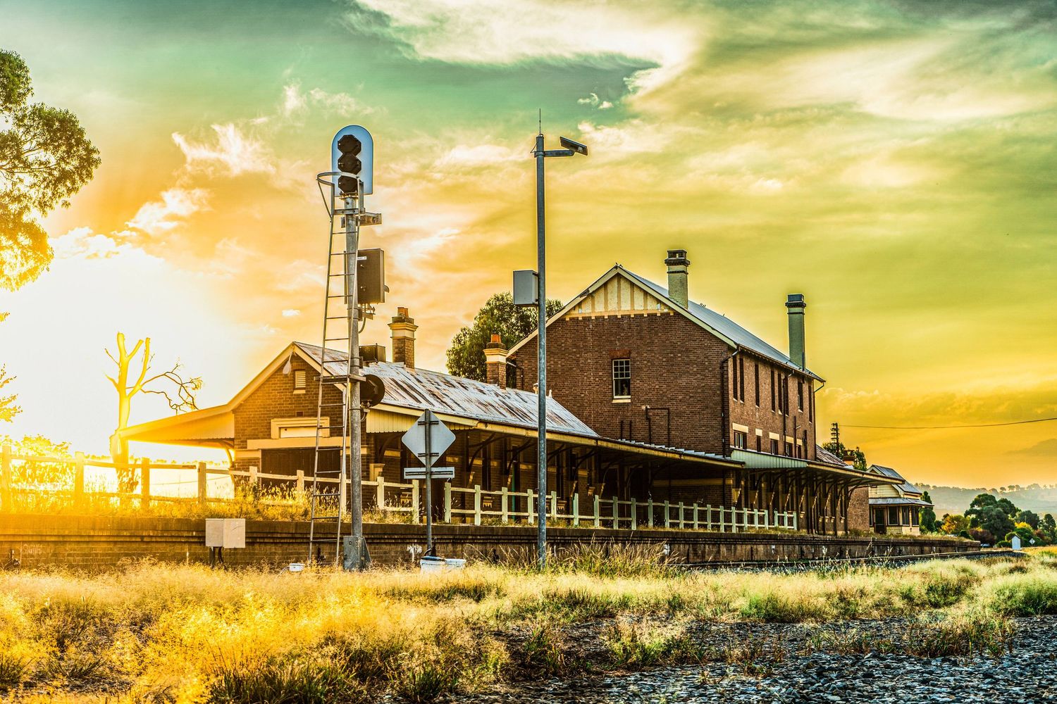 The old Cootamundra West Railway Station with warm colours from the sunset in the background.