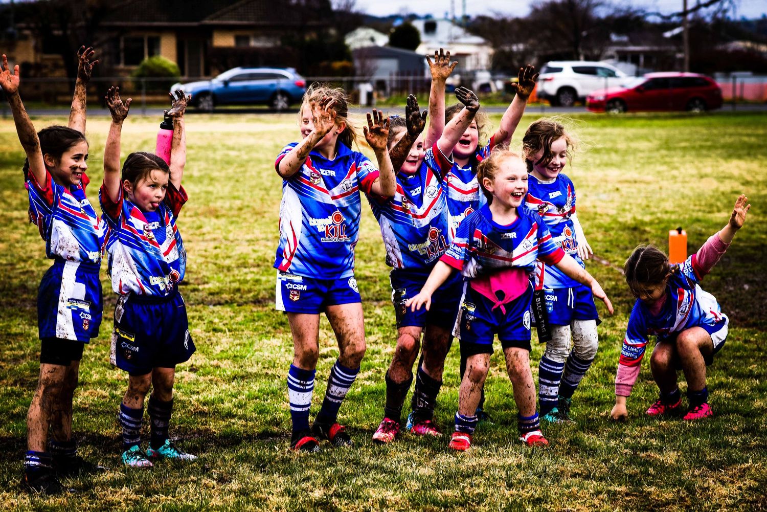 Kids playing in the mud after winning their league tag game, representing the Cootamundra Bulldogs.