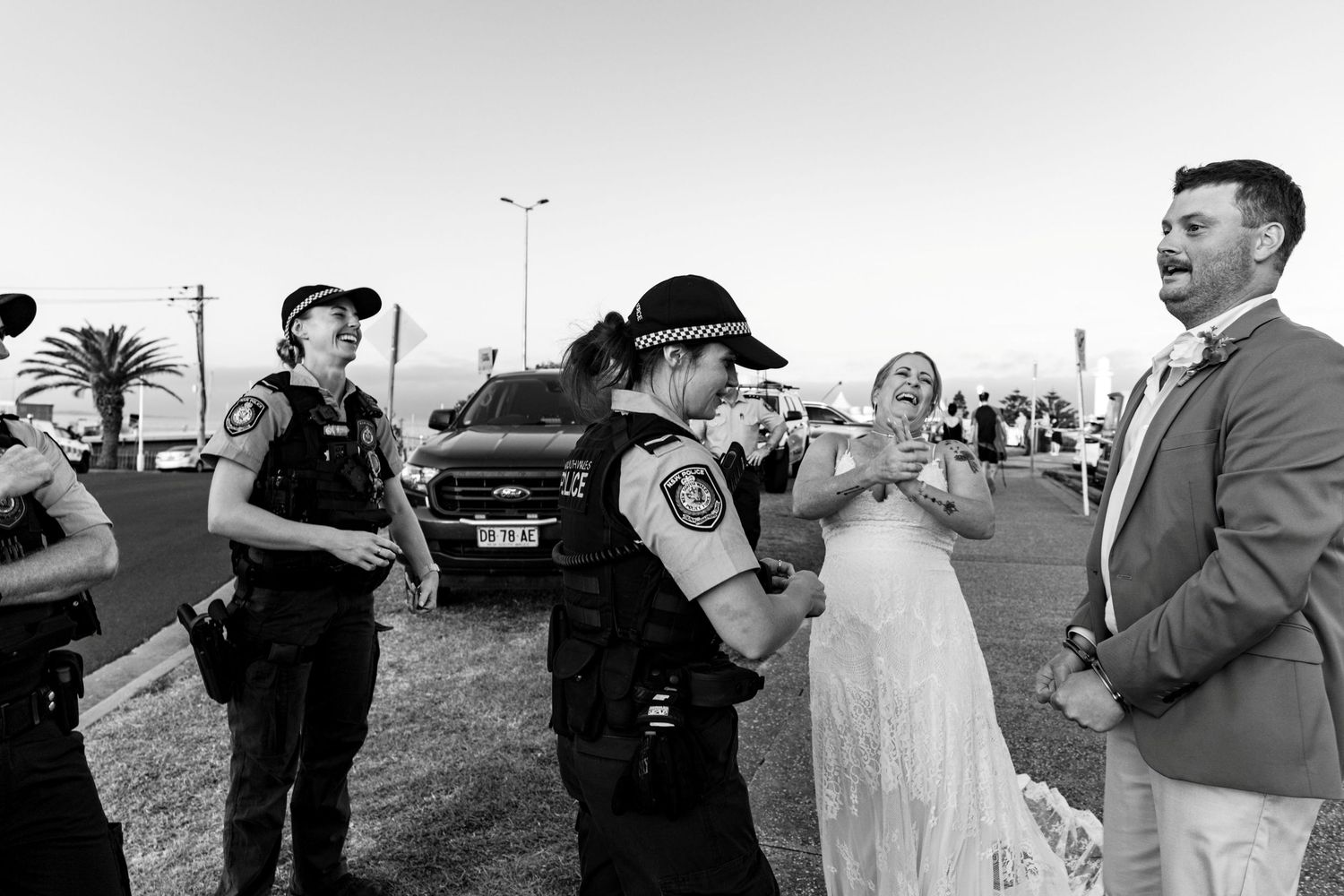 An award winning street style photograph of the groom getting arrested at his Wollongong wedding.