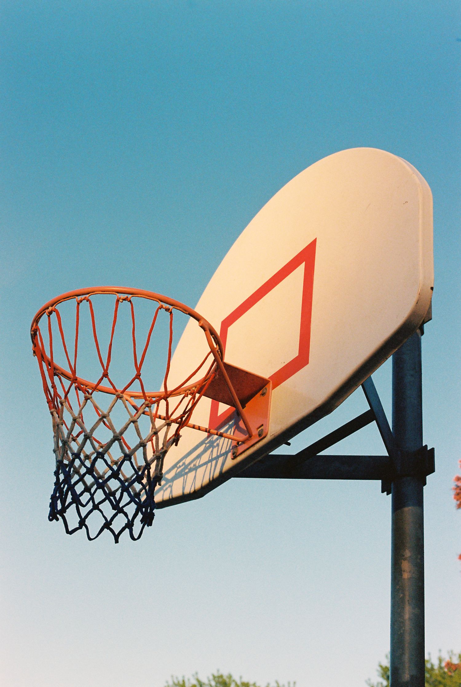 Basketball hoops against a bright blue sky showing different angles and perspectives.