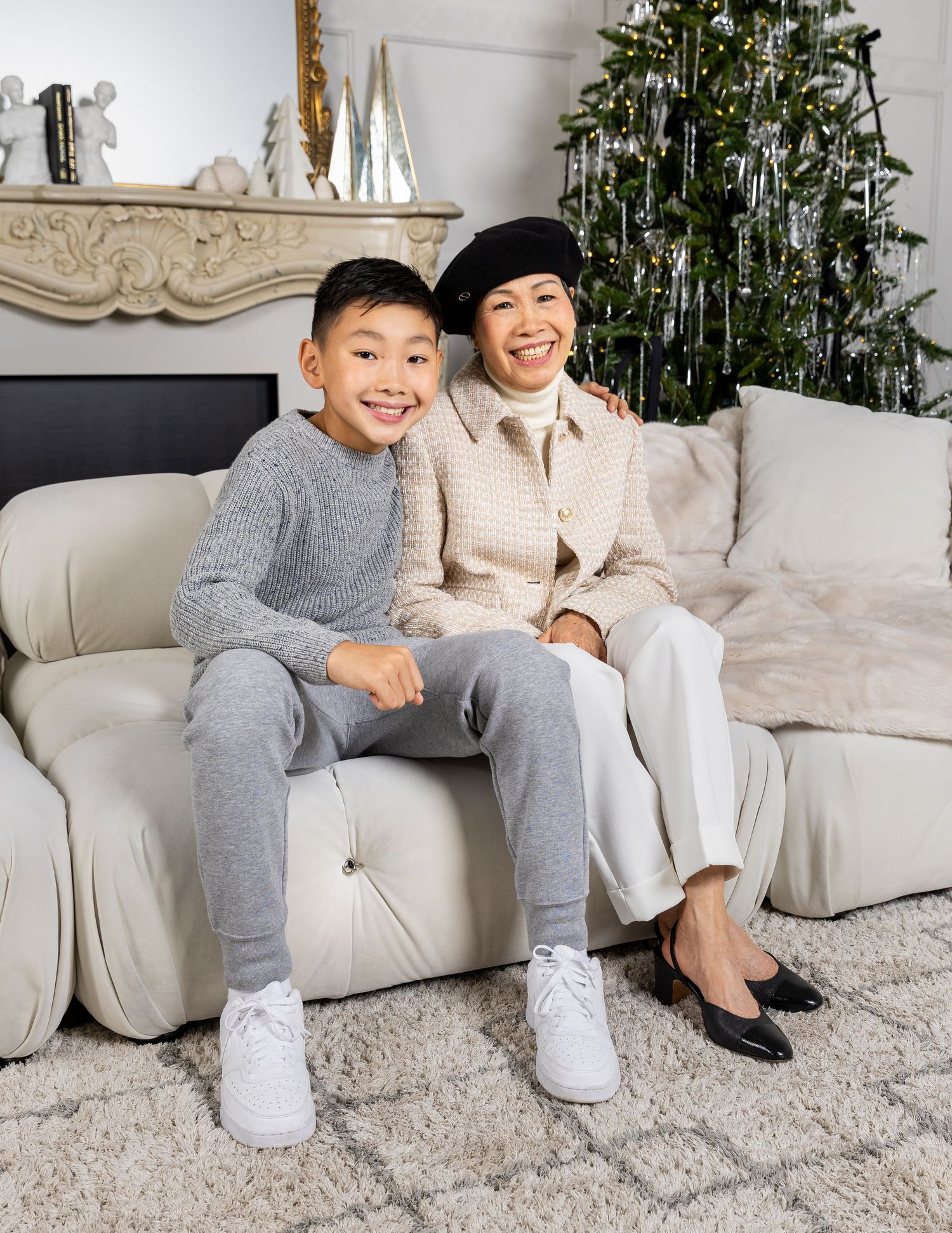 Holiday family photos in living room with decorated Christmas tree and white couch.