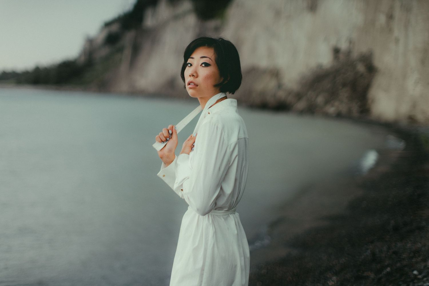 Ethereal outdoor portraits in white dress against misty natural backdrop.